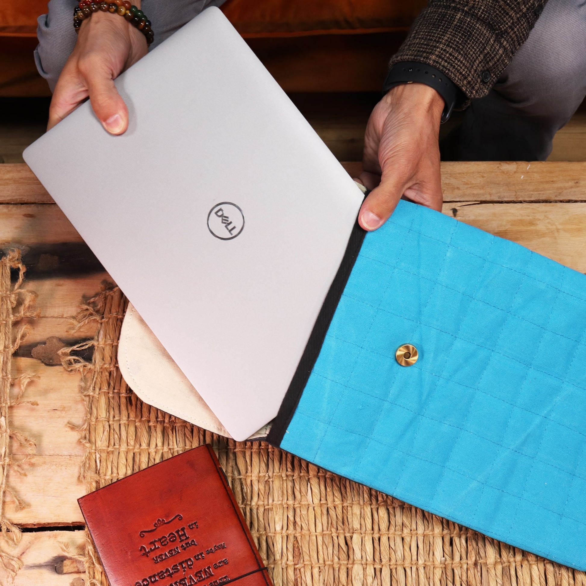 Funda de laptop azul con botón, material acolchado, ideal para proteger laptops Dell y otros de 13-15 pulgadas.