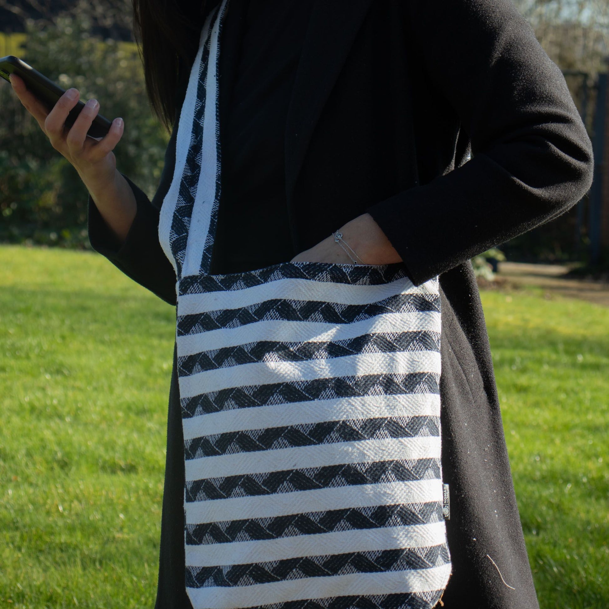 Bolso bandolera de rayas negras y blancas, tejido de algodón, estilo moderno y funcional. Ideal para uso diario.