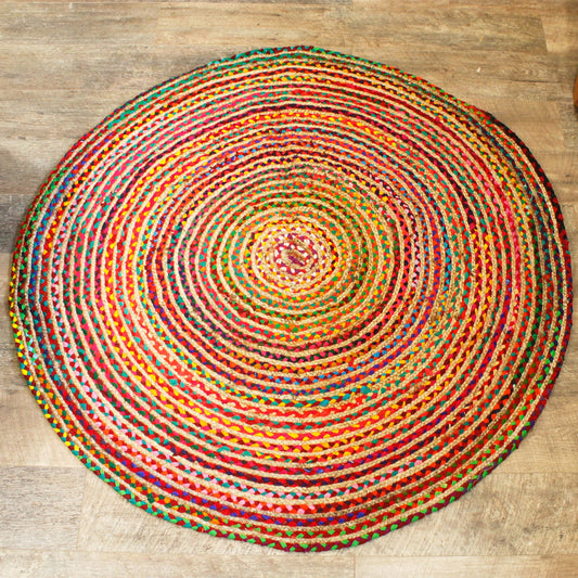 Alfombra redonda de 150 cm hecha de yute y algodón reciclado trenzado en colores vibrantes, estilo rústico y artesanal.