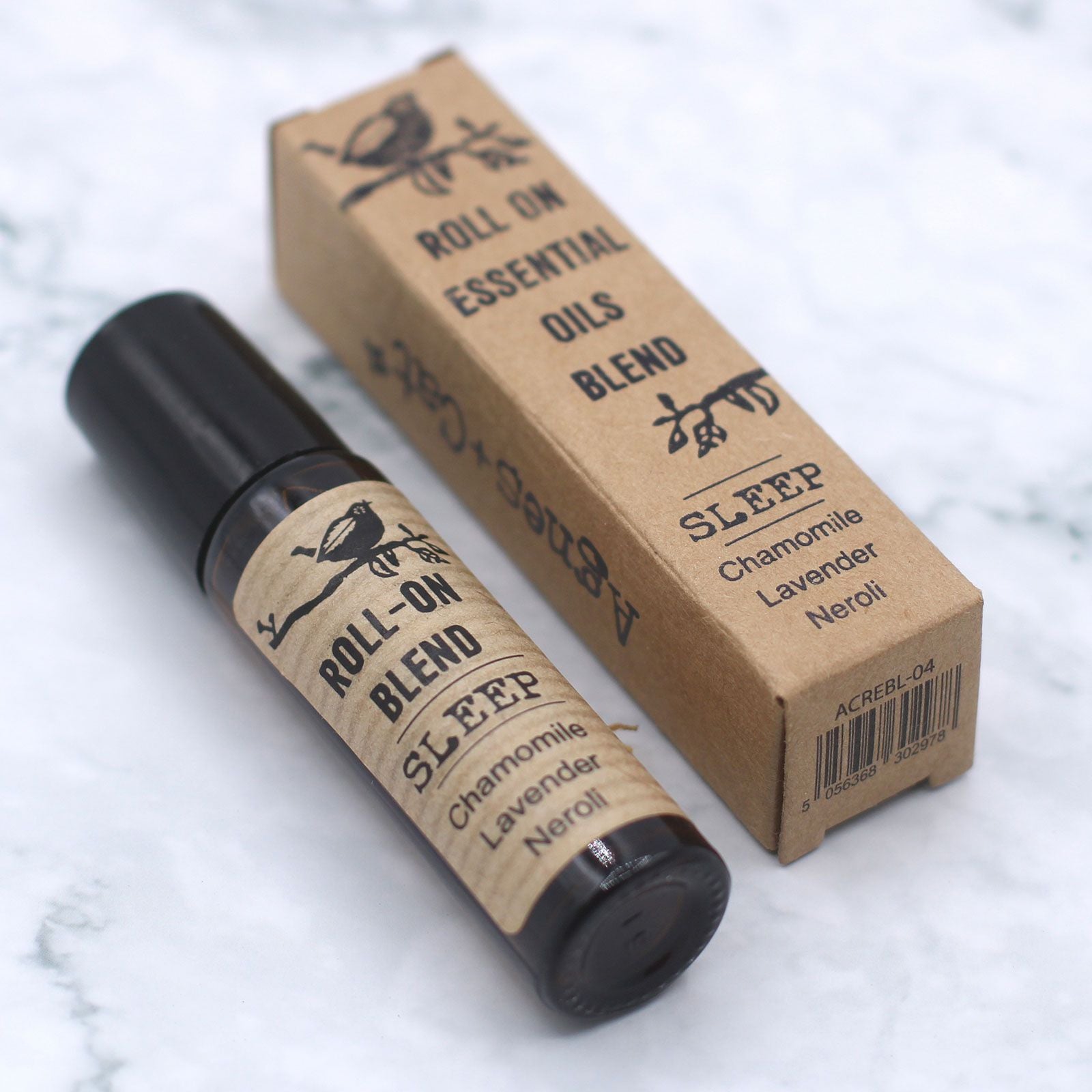 Roll-on de aceites esenciales para dormir en frasco de vidrio oscuro y caja de cartón kraft, estilo natural.