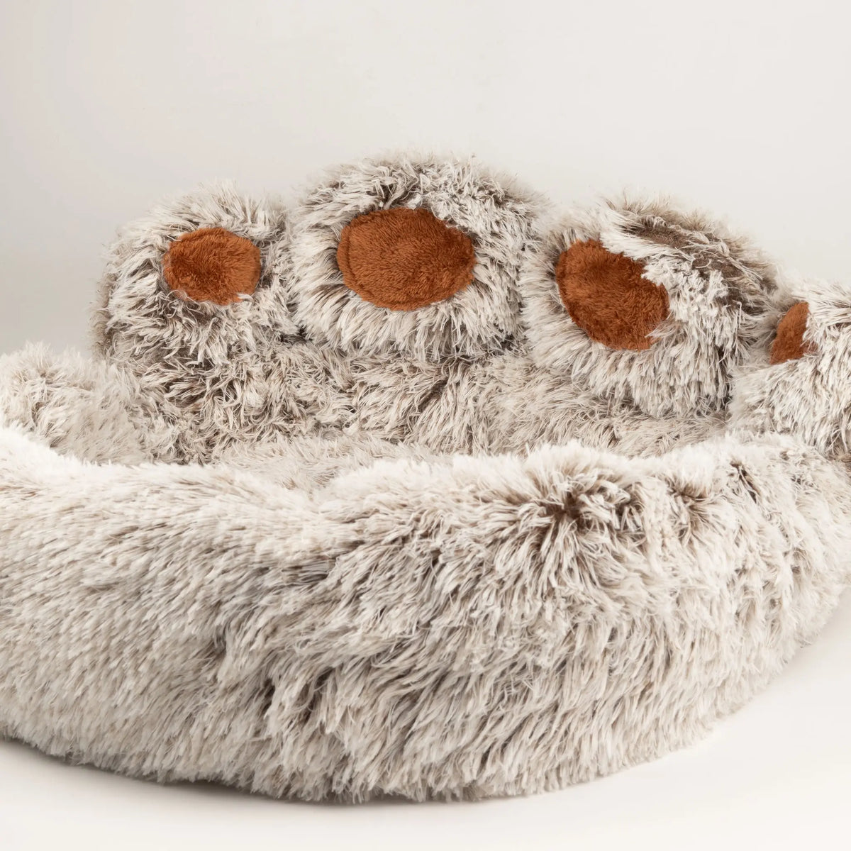Vista en ángulo de la cama para mascotas con forma de huella y bordes acolchados