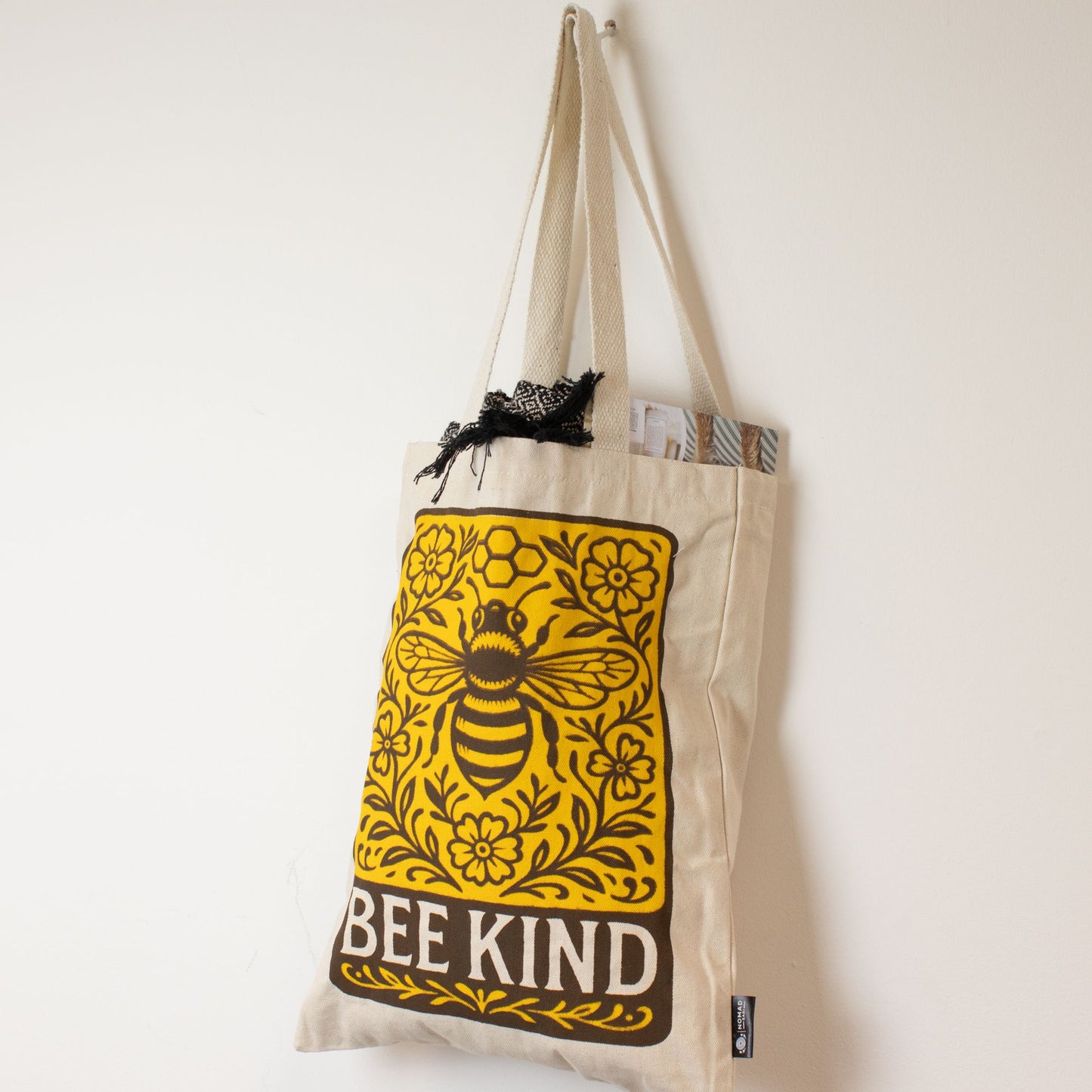 Bolsa de tela beige con diseño de abeja amarilla y texto "BEE KIND", ideal para compras ecológicas.