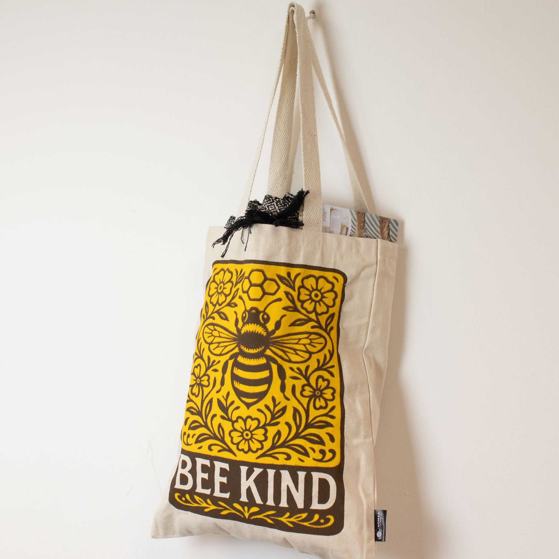 Bolsa de tela beige con diseño de abeja amarilla y texto "BEE KIND", ideal para compras ecológicas.