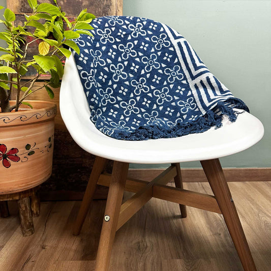 Manta azul con diseño floral y estampado geométrico, de algodón, ideal para decorar y abrigar espacios.