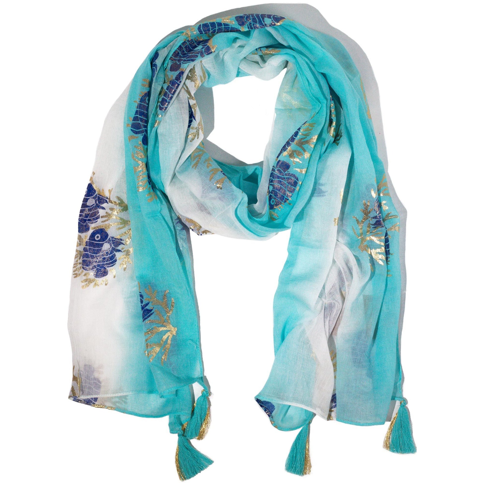 Pañuelo ligero en tonos aqua y blanco con estampado de flores azules y doradas, acabado con borlas.