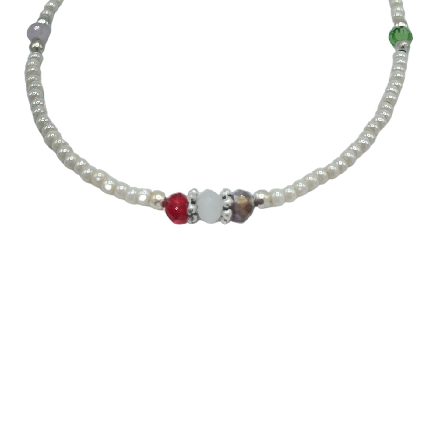 Collar de perlas blancas con cuentas de colores rojo, verde y púrpura, estilo bohemio y vibrante.
