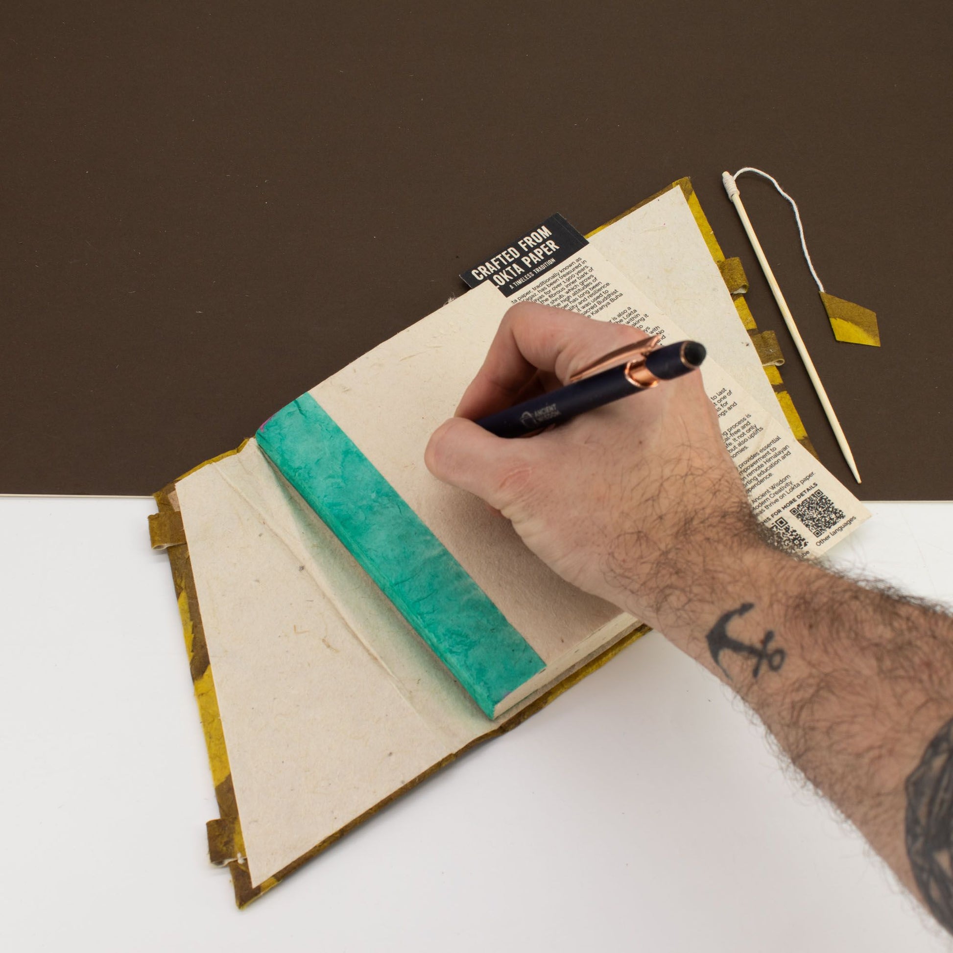 Cuaderno artesanal con cubierta verde turquesa y páginas de papel reciclado, ideal para notas y dibujos.