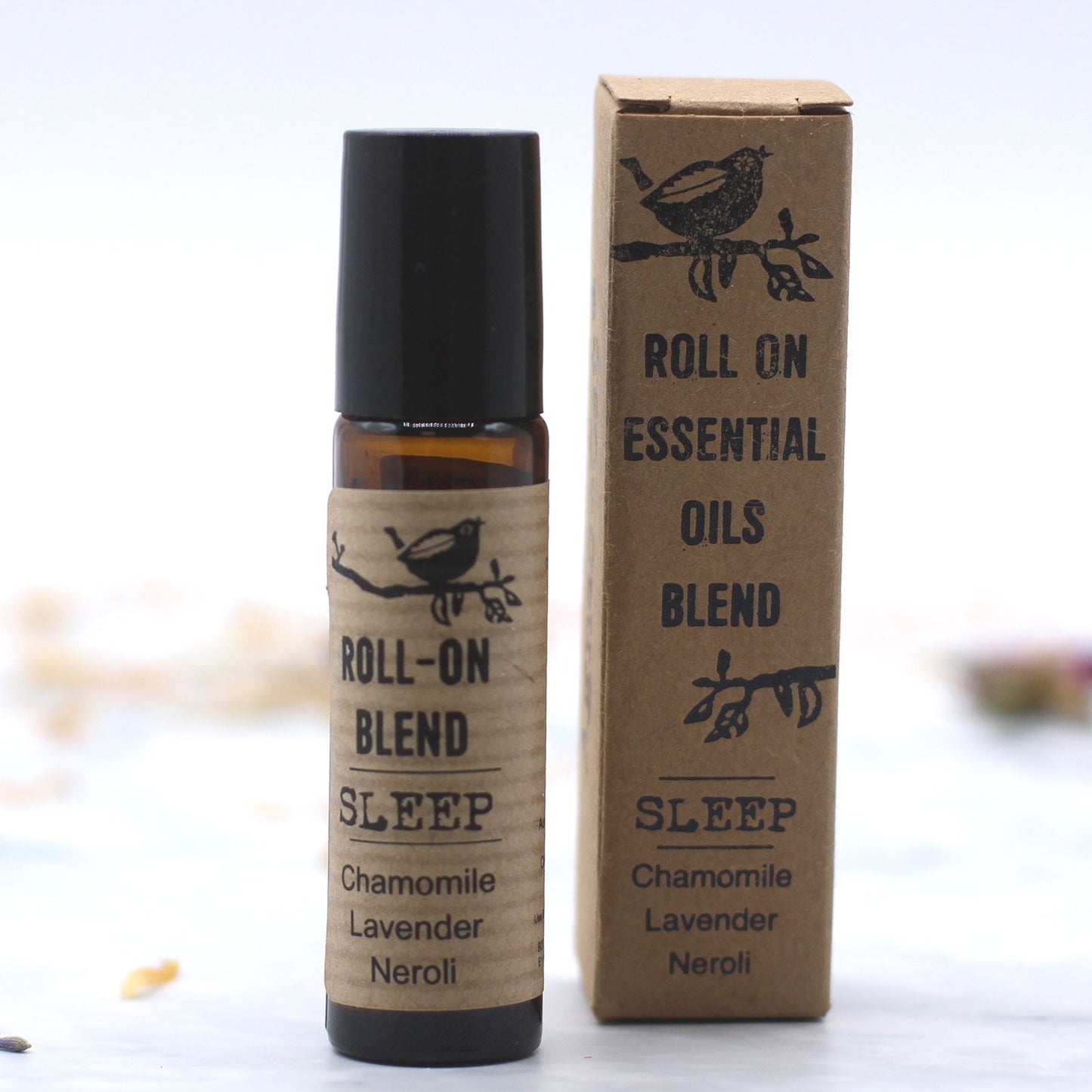 Frasco roll-on de vidrio ámbar y caja de cartón kraft con estilo natural para aceites esenciales de relajación.