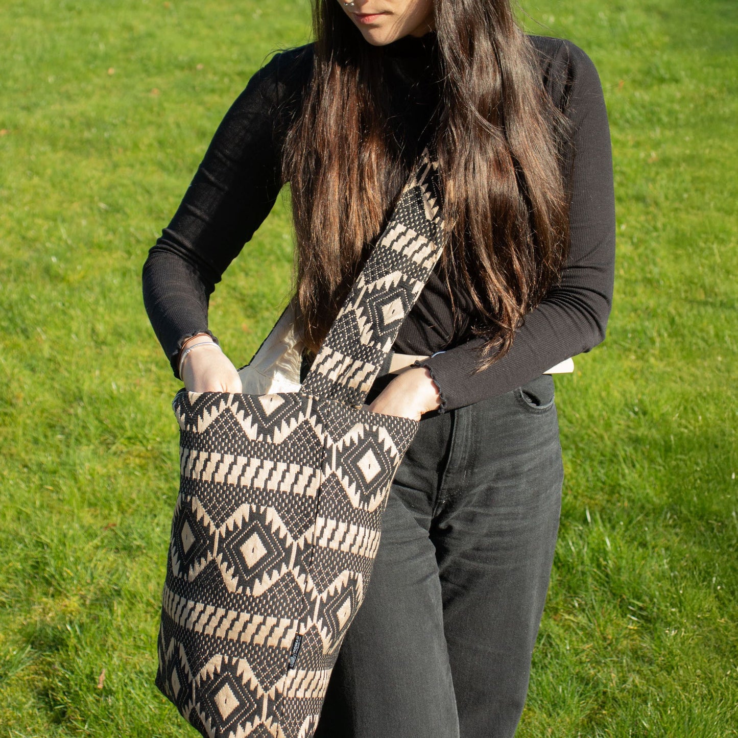 Bolso de lona negro y beige con diseño tribal, estilo bohemio, ideal para uso diario.