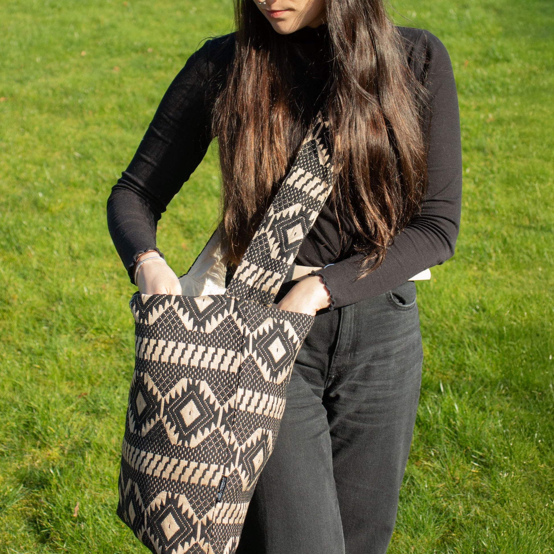 Bolso de lona negro y beige con diseño tribal, estilo bohemio, ideal para uso diario.