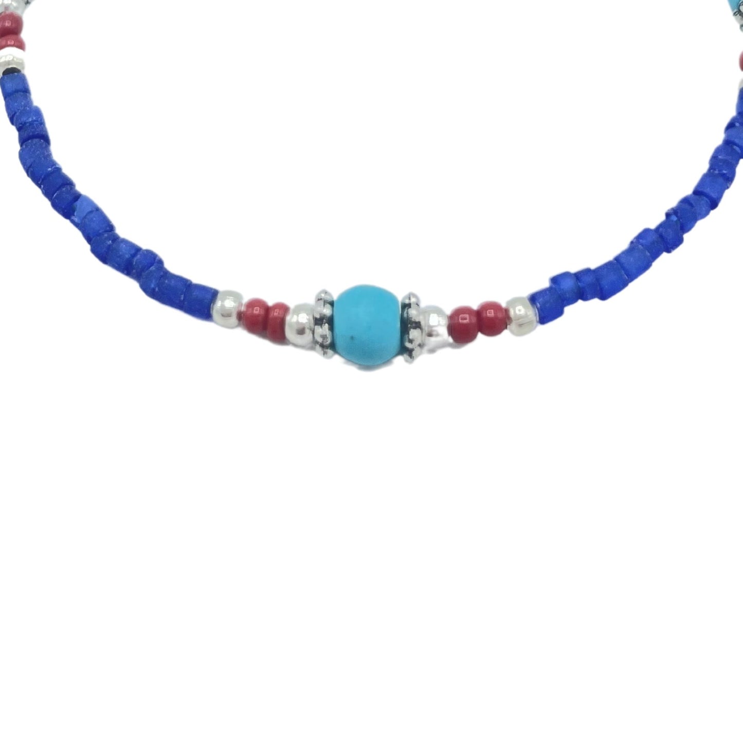 Collar hecho a mano con cuentas azules, rojas y plateadas, estilo bohemio y colorido.