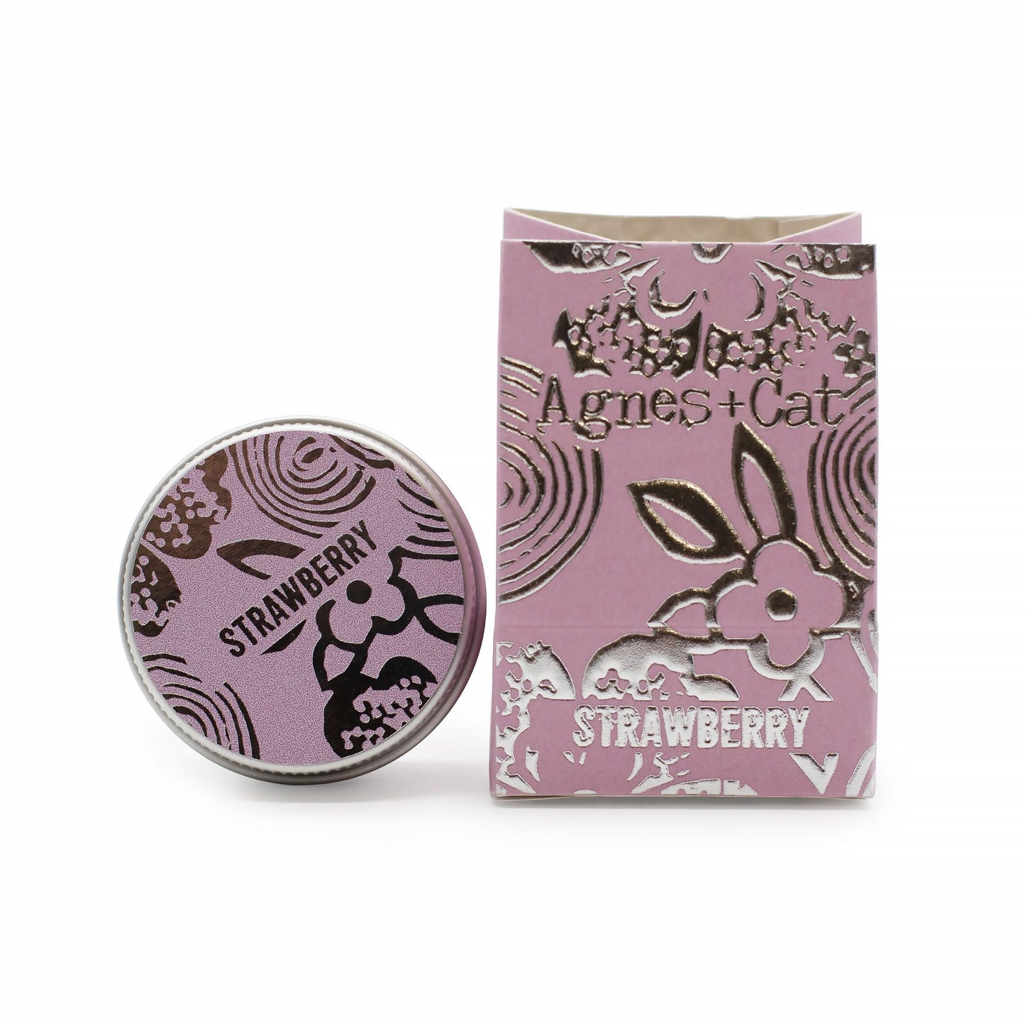 Bálsamo labial de fresa Agnes + Cat en caja y lata redonda de color rosa con detalles plateados y estilo floral.