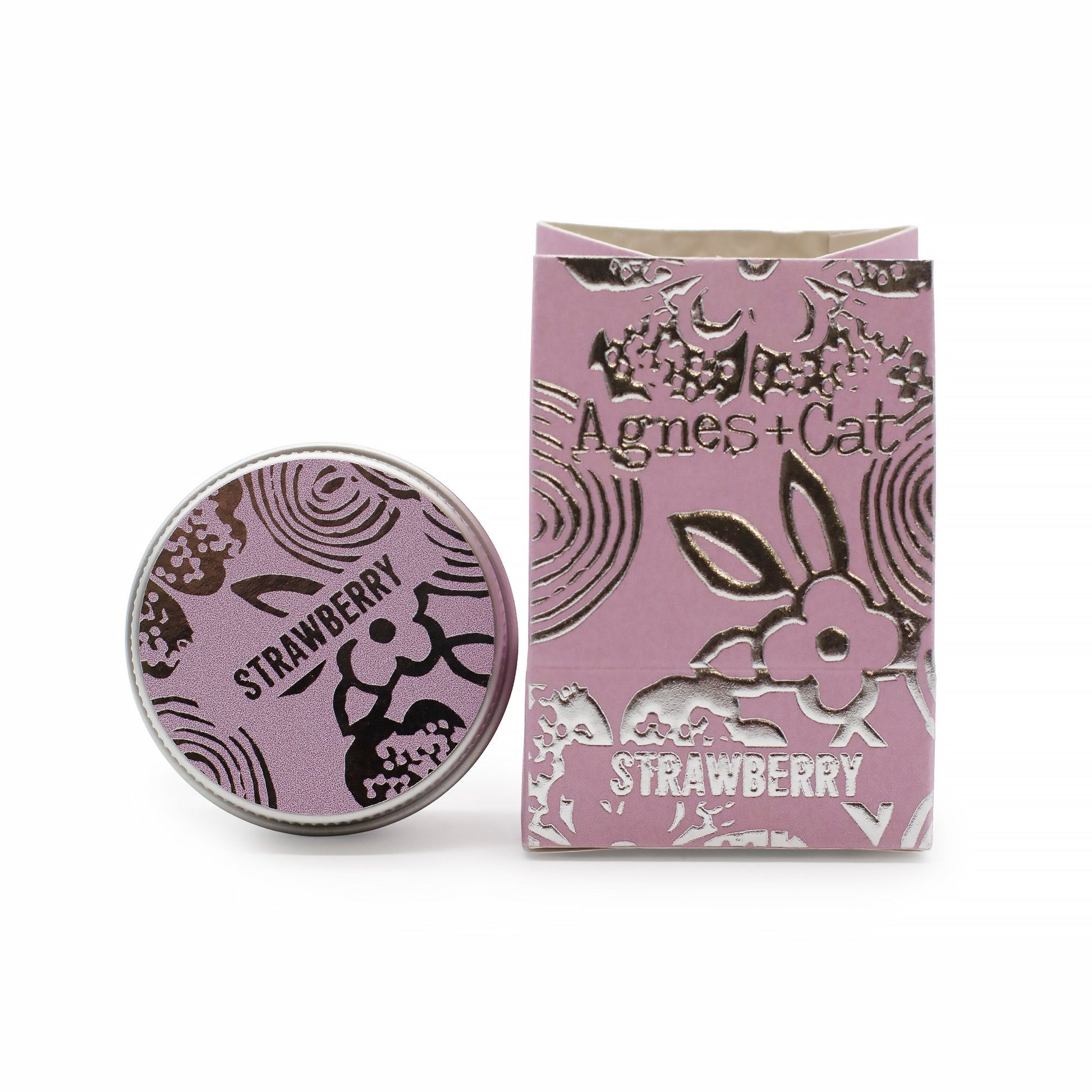 Bálsamo labial de fresa Agnes + Cat en caja y lata redonda de color rosa con detalles plateados y estilo floral.