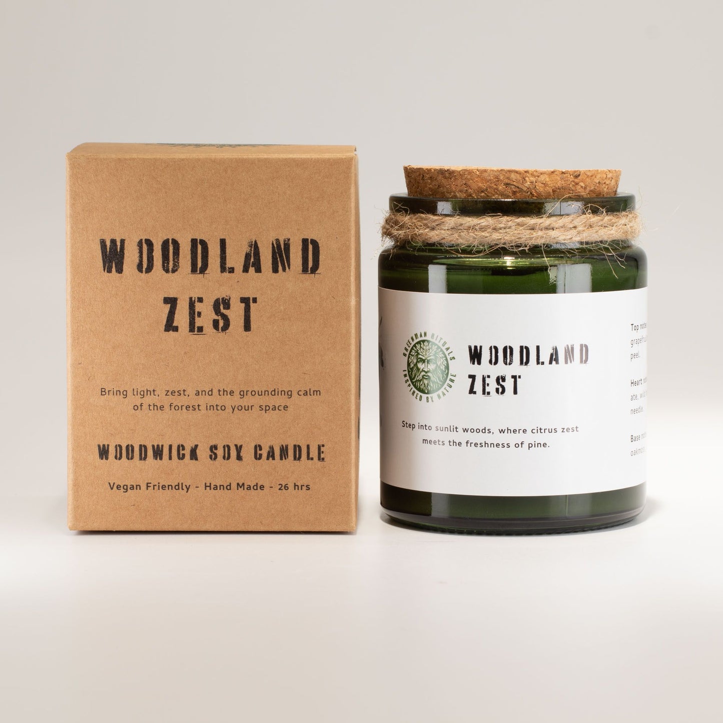 Vela de soja verde "Woodland Zest" en envase de cristal, con aroma a cítricos y pino, presentada en caja kraft.