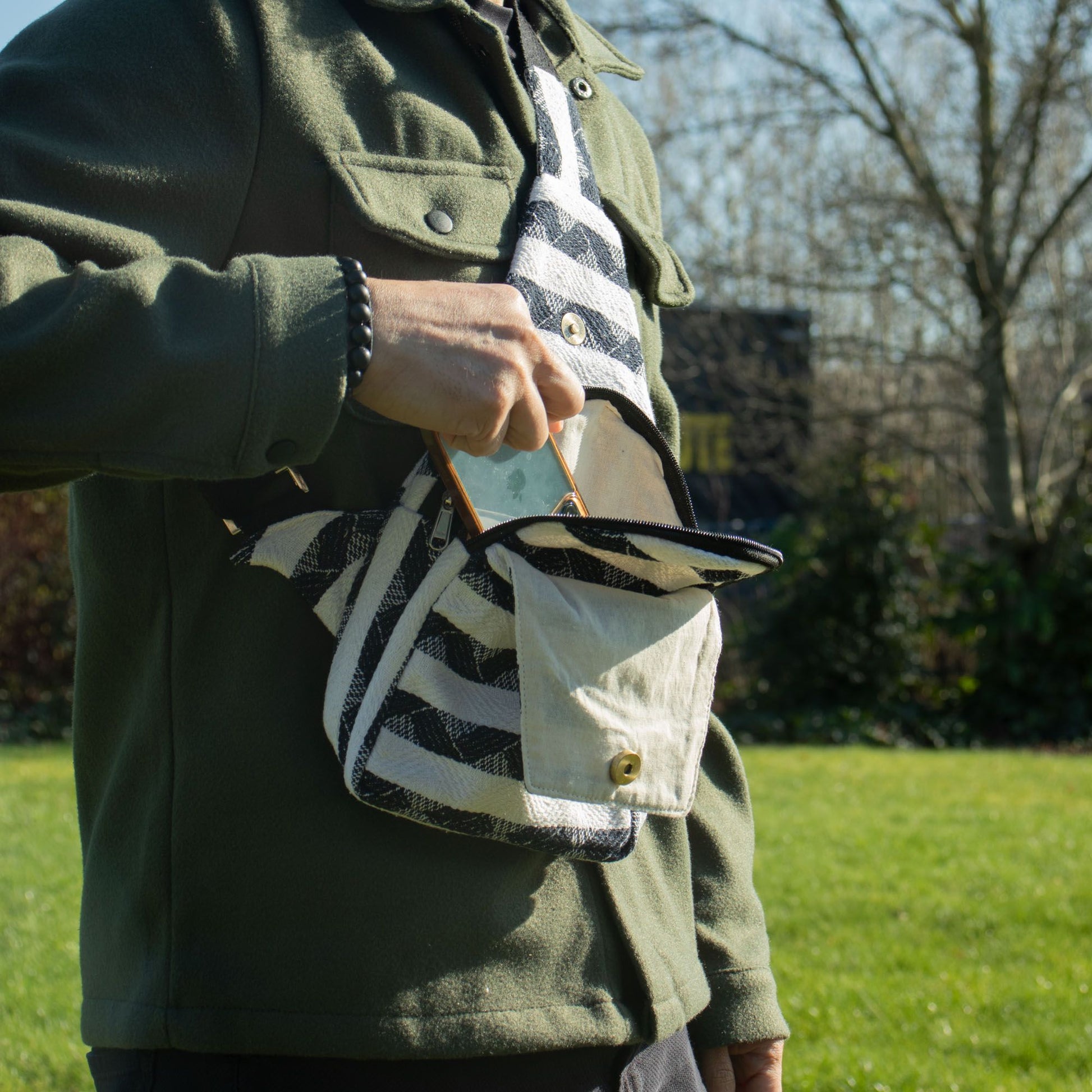 Bolso de mano negro y blanco de tela con tirantes, estilo casual, ideal para uso diario.
