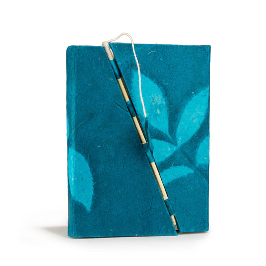Cuaderno hecho a mano en papel reciclado azul con hojas turquesas, atado con hilo de algodón natural.