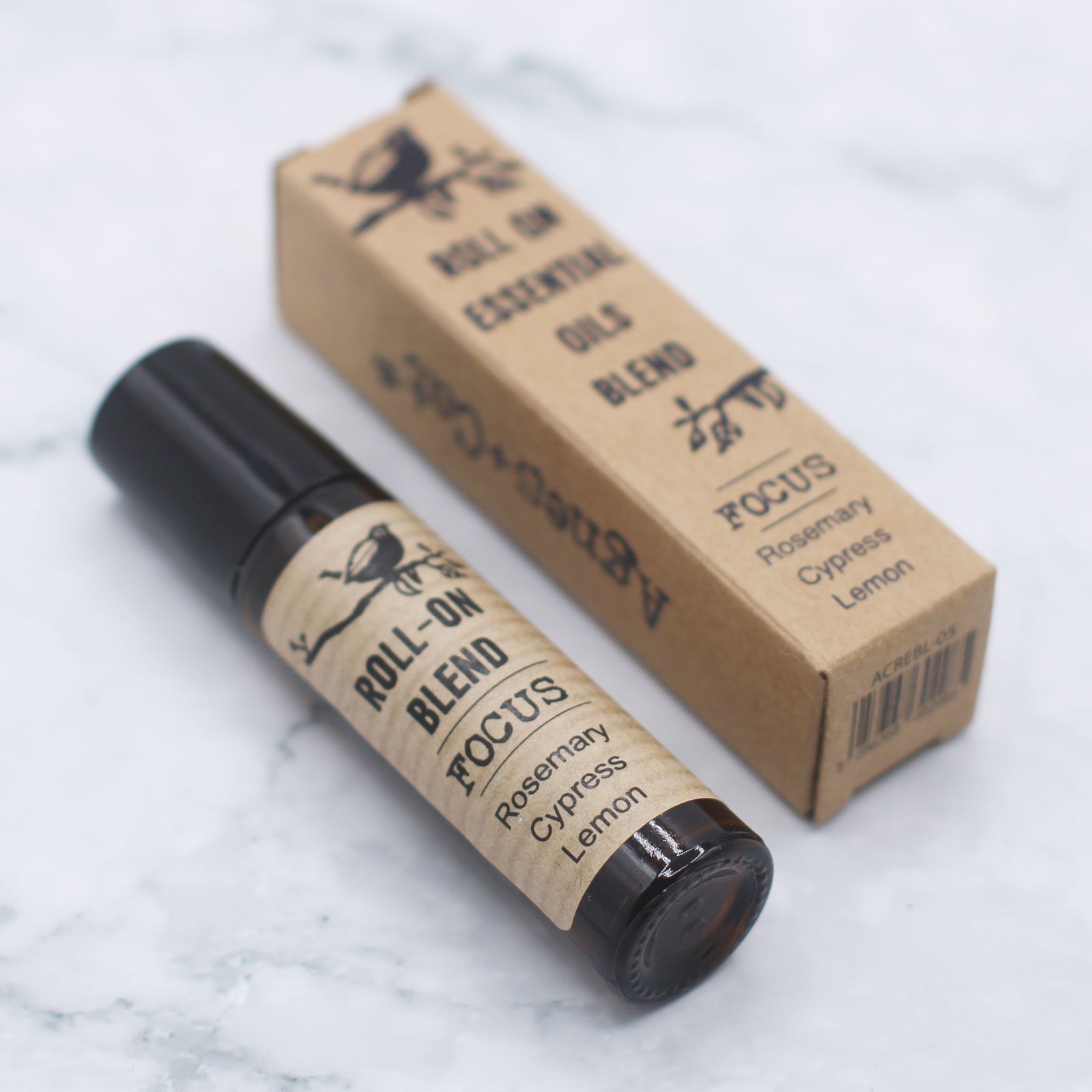 Aceite esencial roll-on "Focus" de romero, ciprés y limón en envase negro con etiqueta kraft. Ideal para concentración.