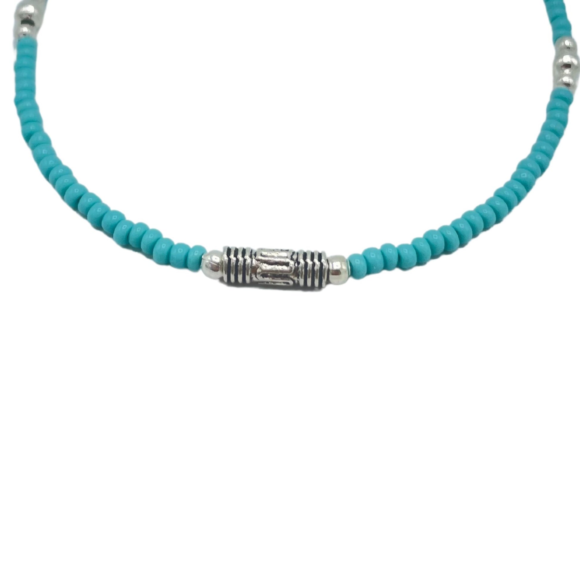 Collar de cuentas de cerámica turquesa con detalles plateados y central en metal, estilo bohemio y veraniego.