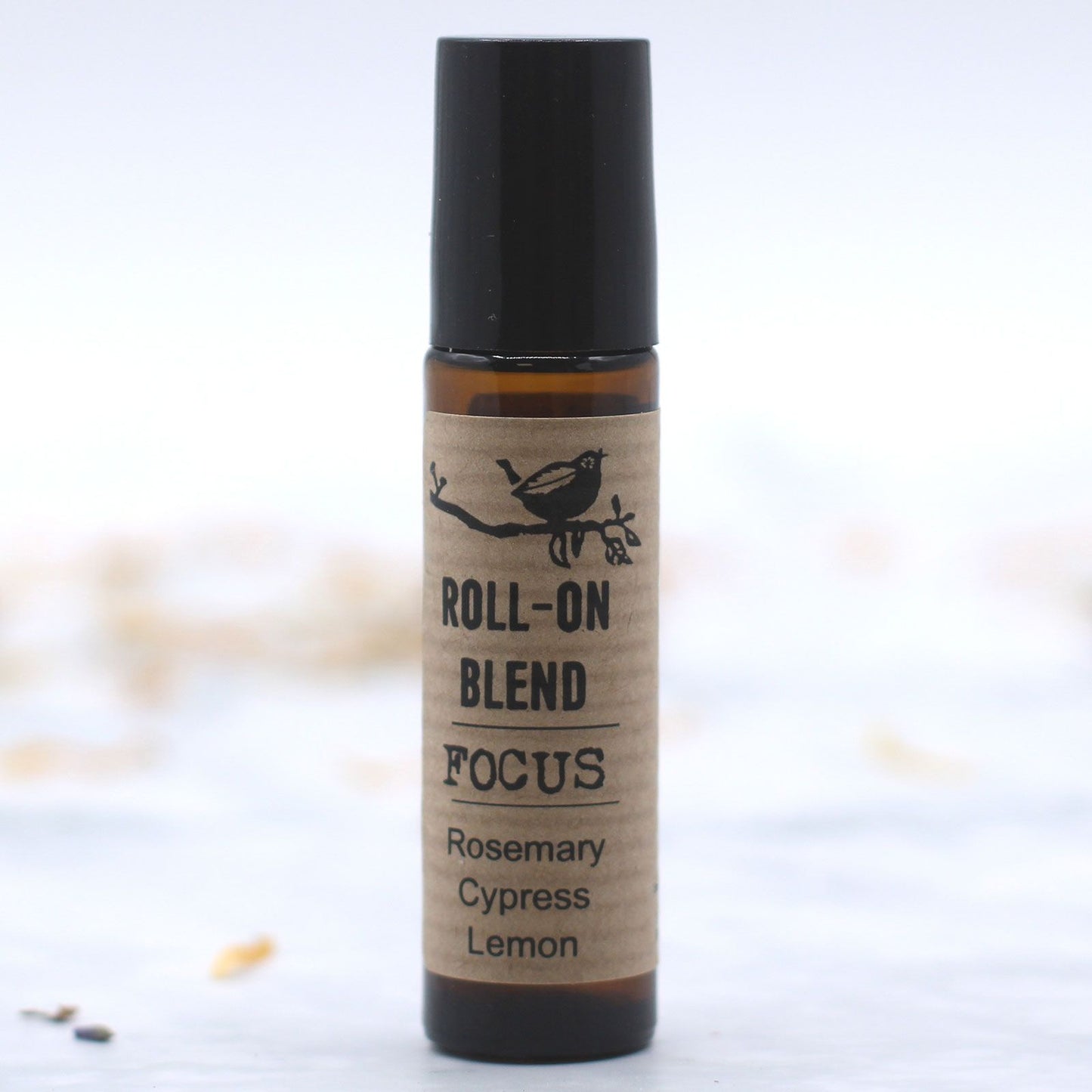 Mezcla roll-on enfocado, aromaterapia de romero, ciprés y limón en frasco de vidrio ámbar con tapa negra.