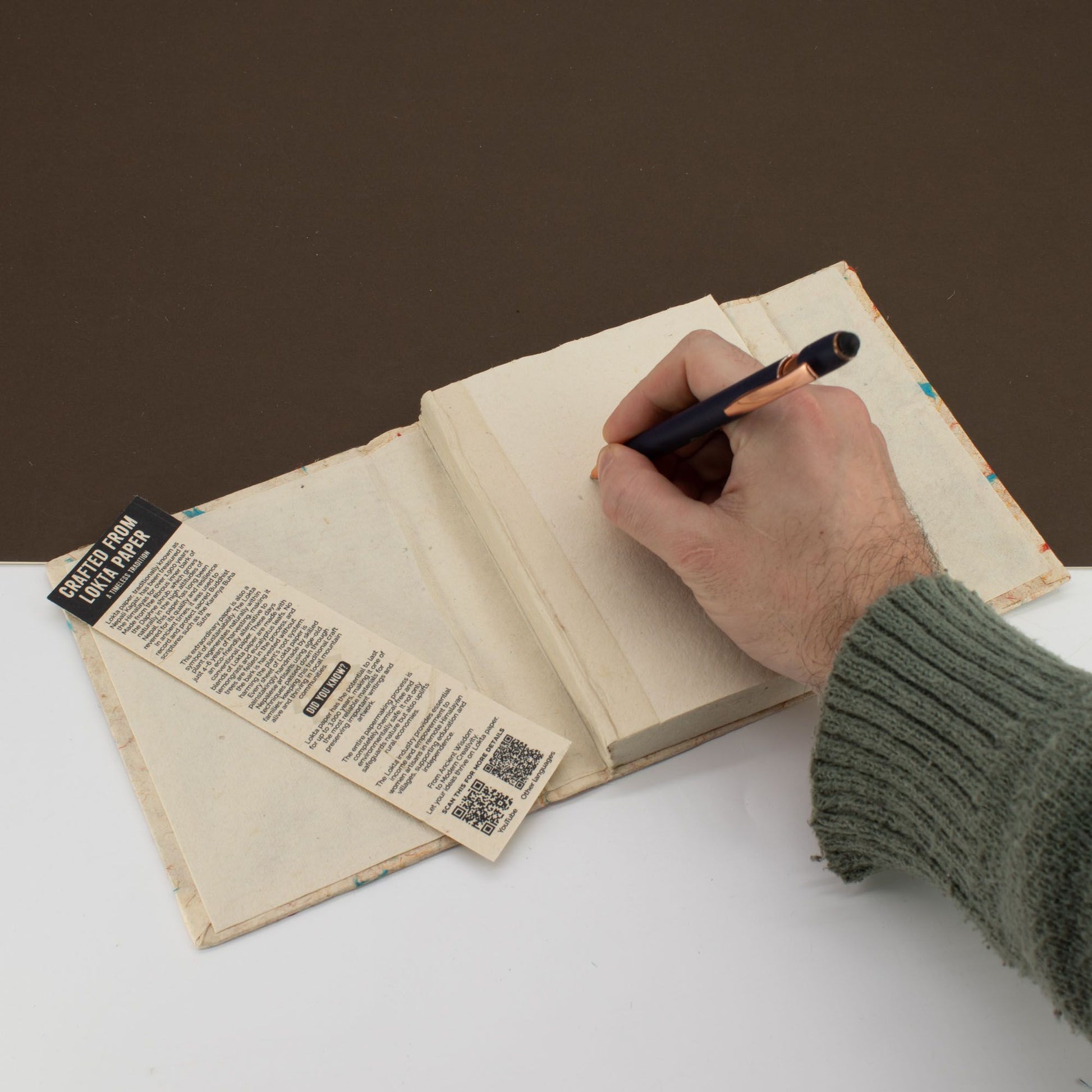 Cuaderno en blanco con tapas de papel reciclado, estilo rústico, y marcador de lectura, ideal para anotaciones.