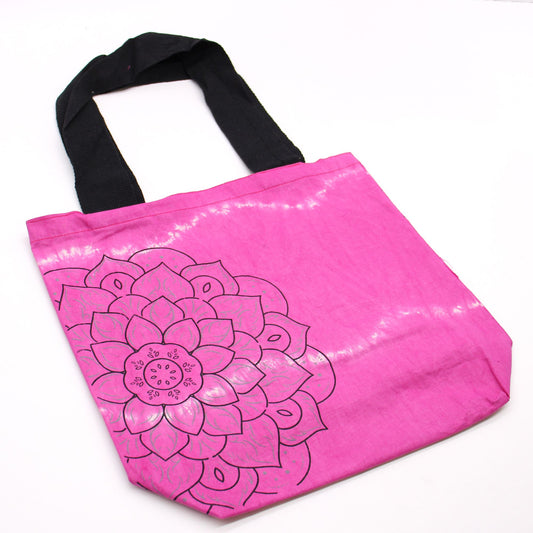 Bolsa de algodón magenta estilo tie-dye con estampado de mandala negro y asas largas negras sobre fondo blanco.