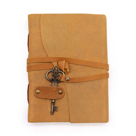 Cuaderno de cuero marrón claro con cierre de cinta y llave decorativa, estilo antiguo y vintage.