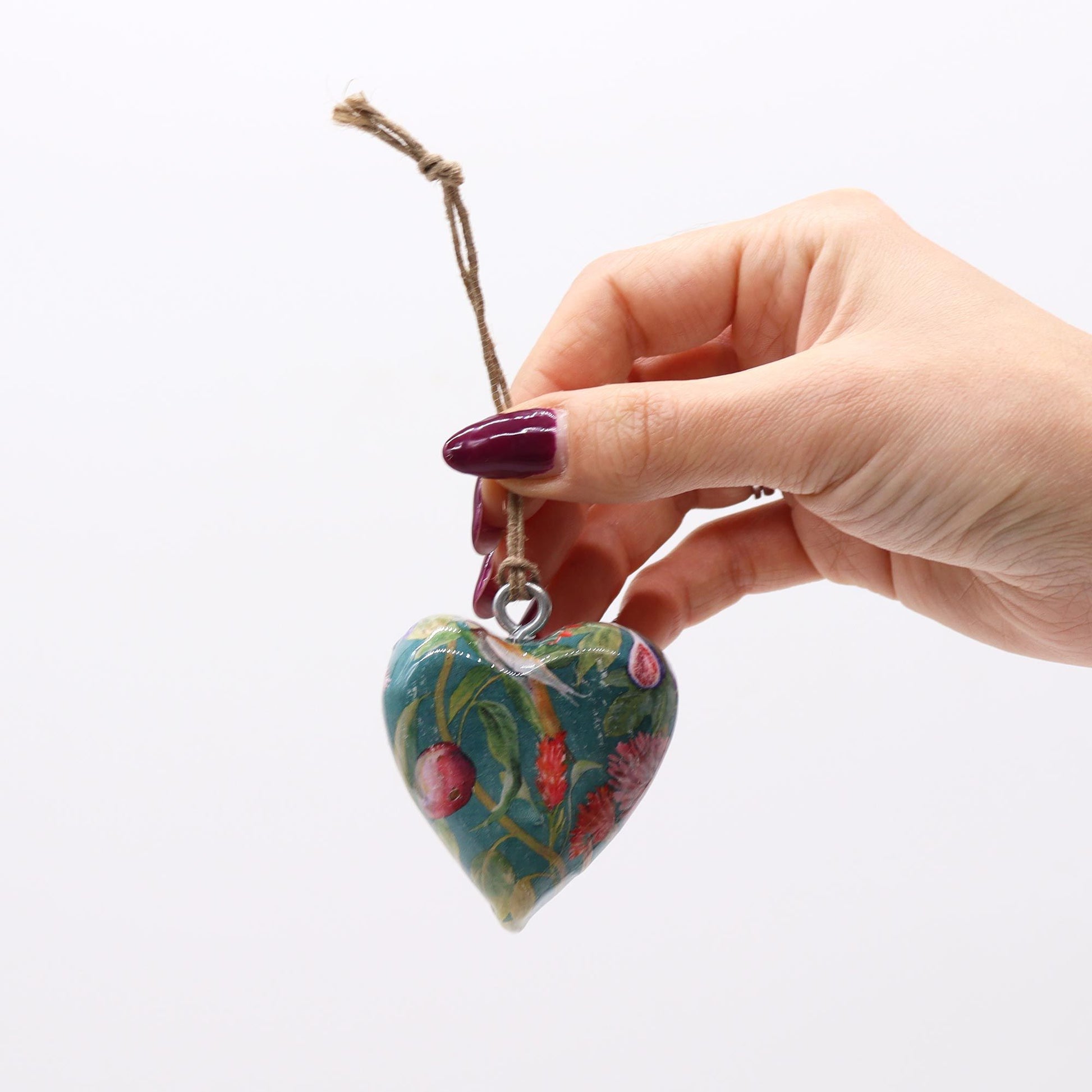 Corazón decorativo de cerámica azul con flores multicolor, colgado con cuerda natural. Ideal para adornos.