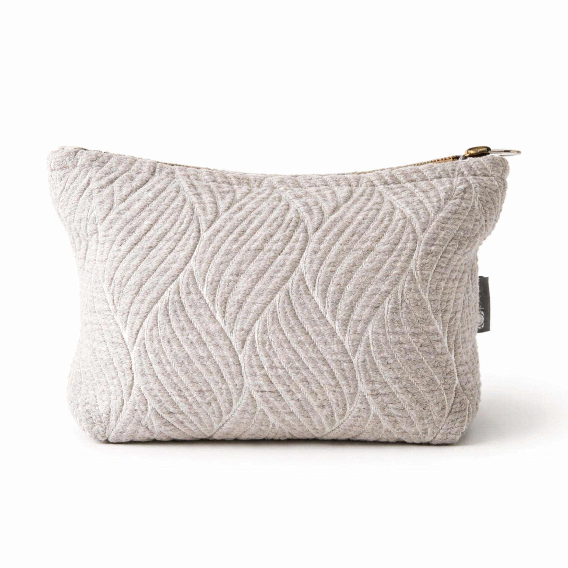 Neceser gris claro con diseño de hojas en relieve, fabricado en tela suave y texturizada. Perfecto para maquillaje.