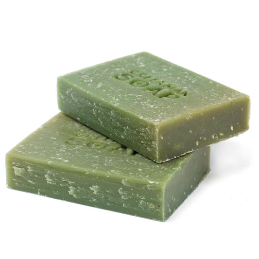 Dos pastillas de jabón verde rectangular con textura exfoliante apiladas sobre un fondo blanco.