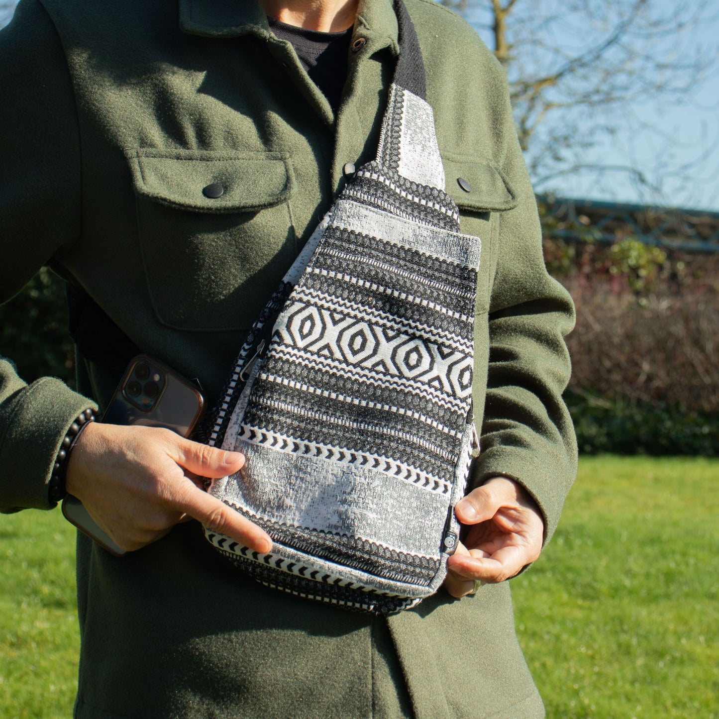 Bolso bandolera negro y gris de tela con estampado étnico, ideal para un estilo casual y moderno.