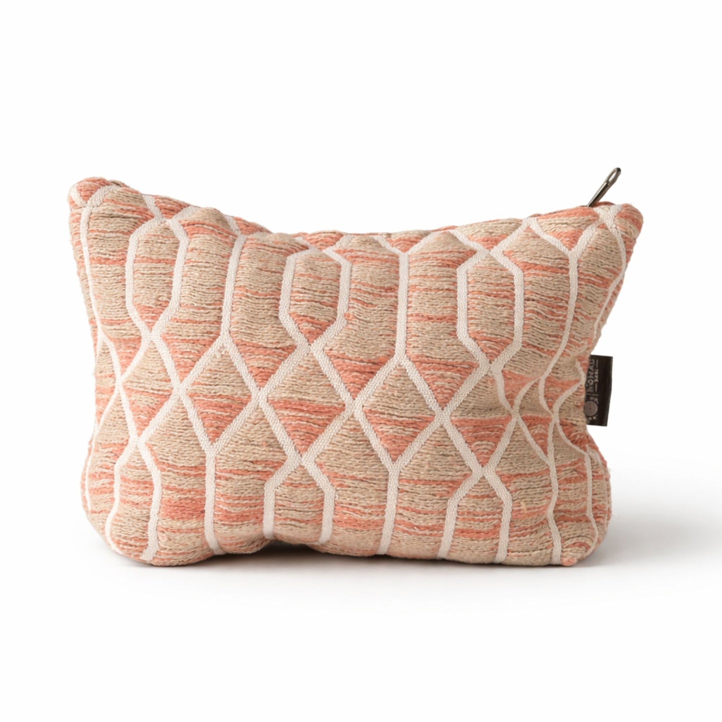 Cojín decorativo de tela en tonos coral y beige, con diseño geométrico y textura suave.