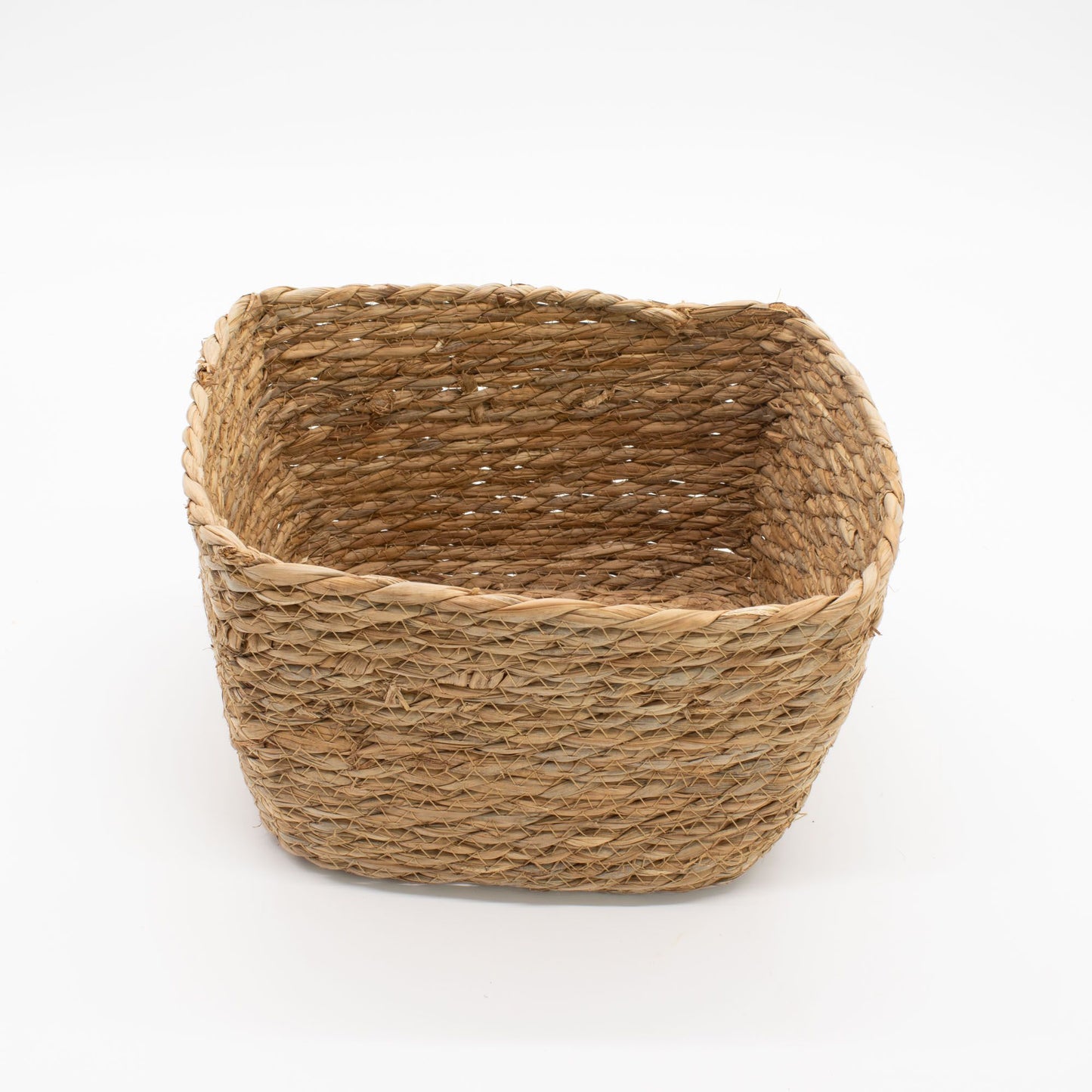 Cesta cuadrada de hierba marina y hoja de plátano tejida a mano, color natural, estilo rústico, fondo blanco.