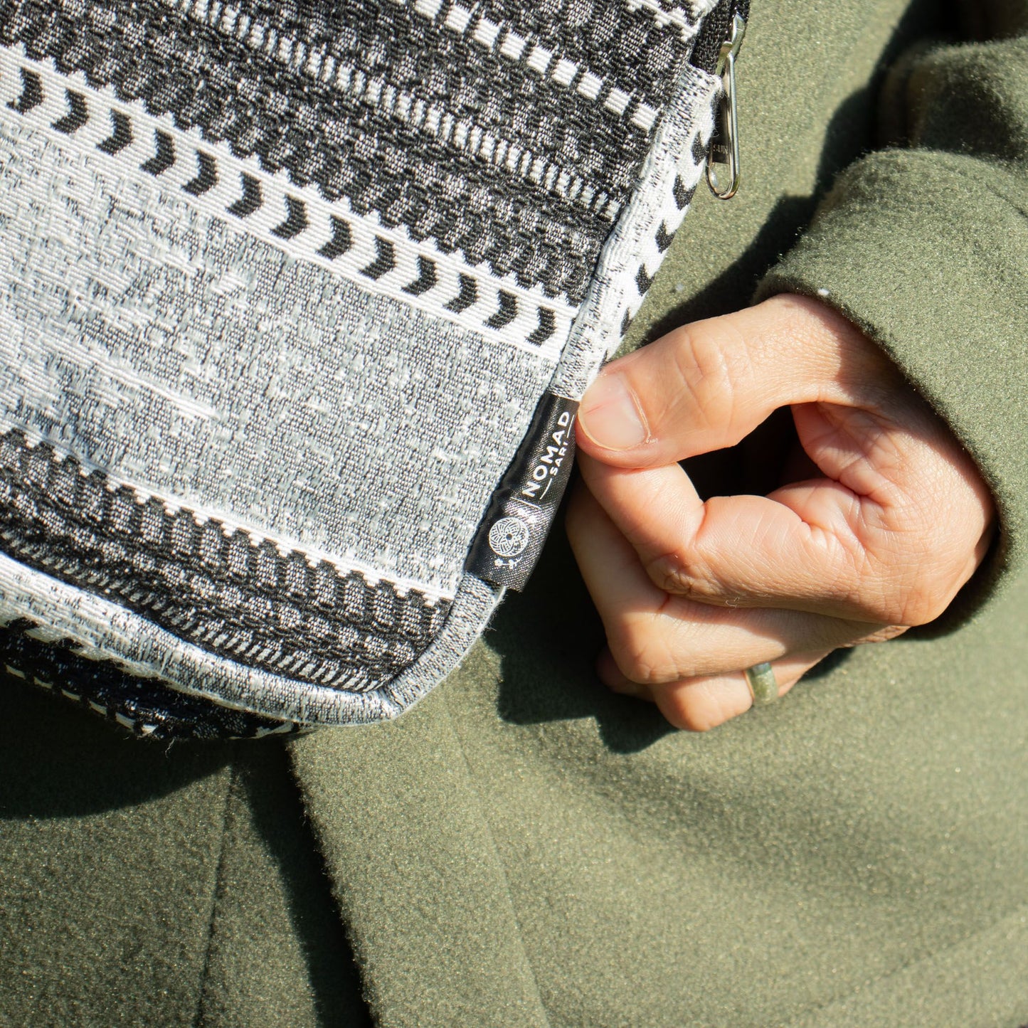 Bolso de hombro negro y gris con diseño étnico, material de tela reciclada, estilo bohemio.