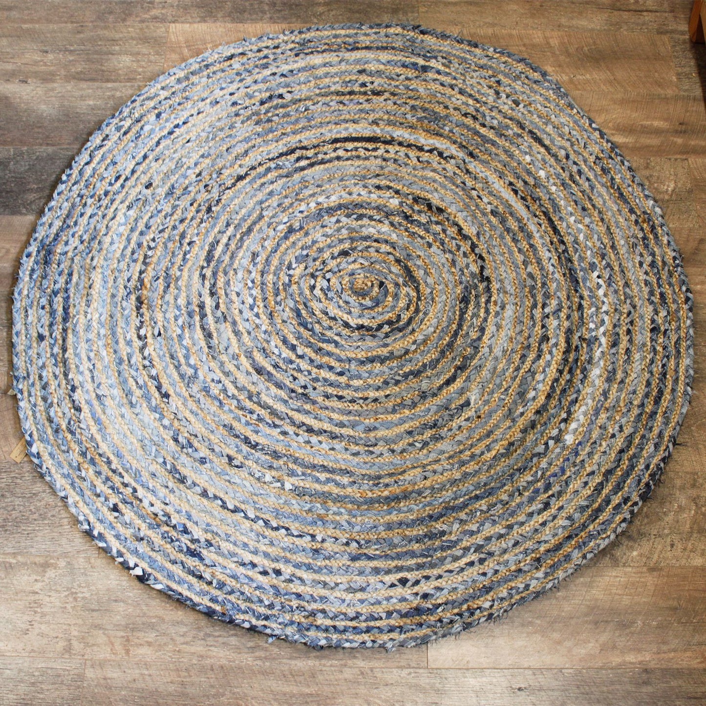 Alfombra redonda de 150 cm hecha con fibras trenzadas de yute natural y mezclilla azul, estilo artesanal y texturizado.