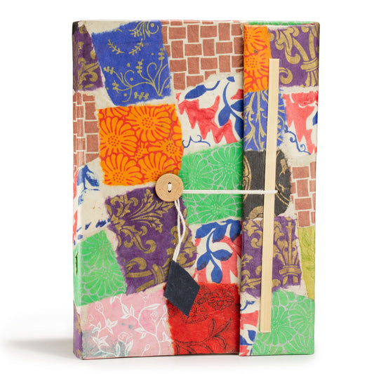 Cuaderno artesanal con cubiertas de papel reciclado colorido en patchwork y cierre de cuerda, estilo bohemio.