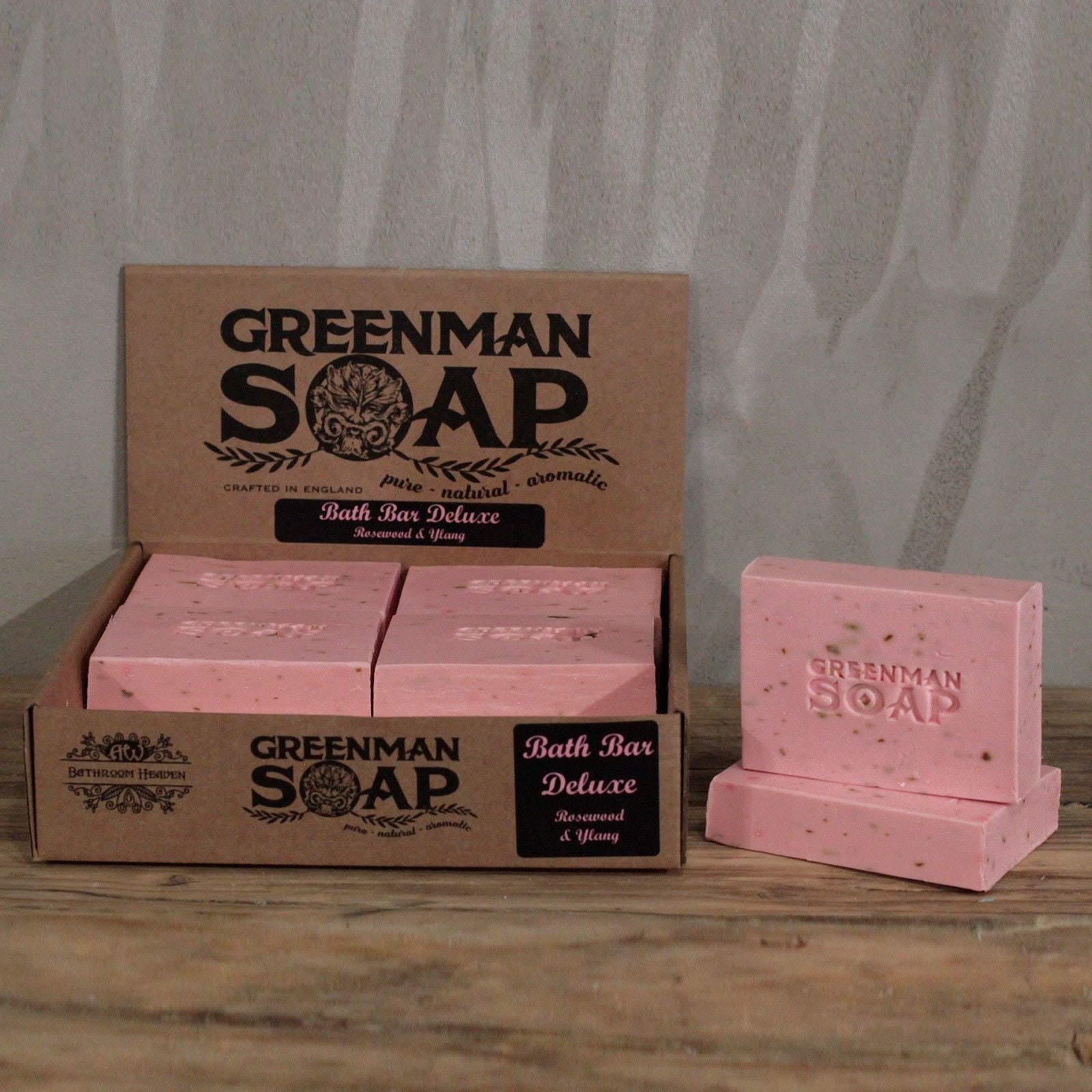 Caja de cartón con jabones Greenman de color rosa, con textura y logo grabado, aroma a palo de rosa e ylang.