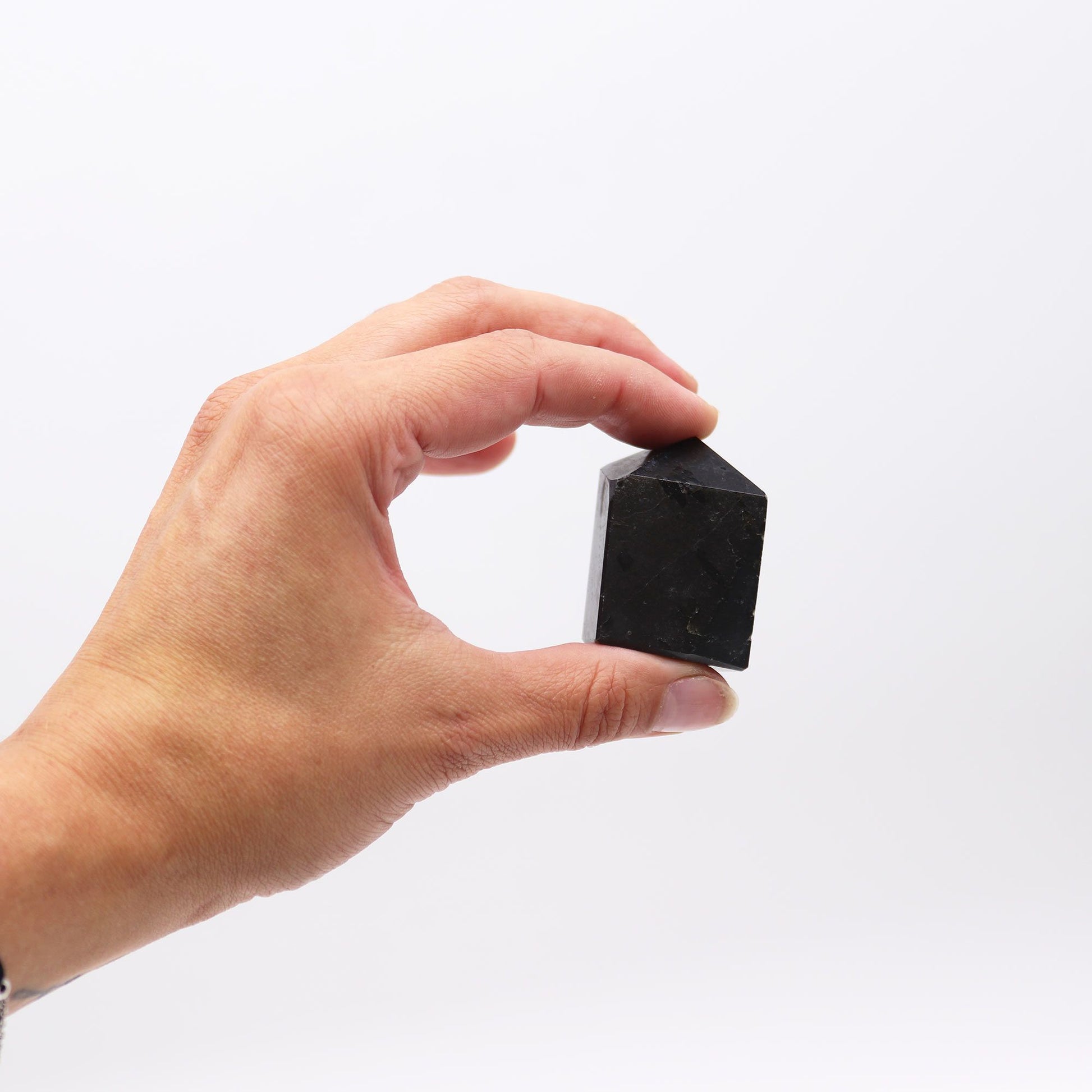 Piedra negra natural en forma de pirámide, ideal para decoración y coleccionismo, 3x5 cm.