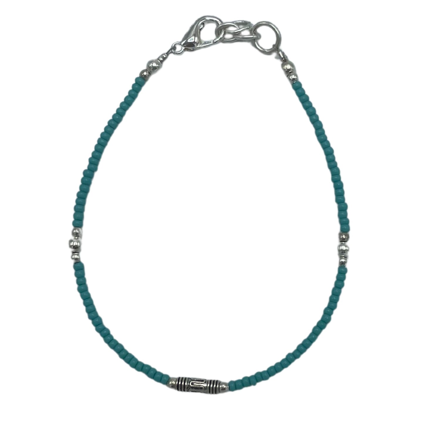 Pulsera de cuentas turquesa con detalles plateados, estilo bohemio y cierre de acero inoxidable.