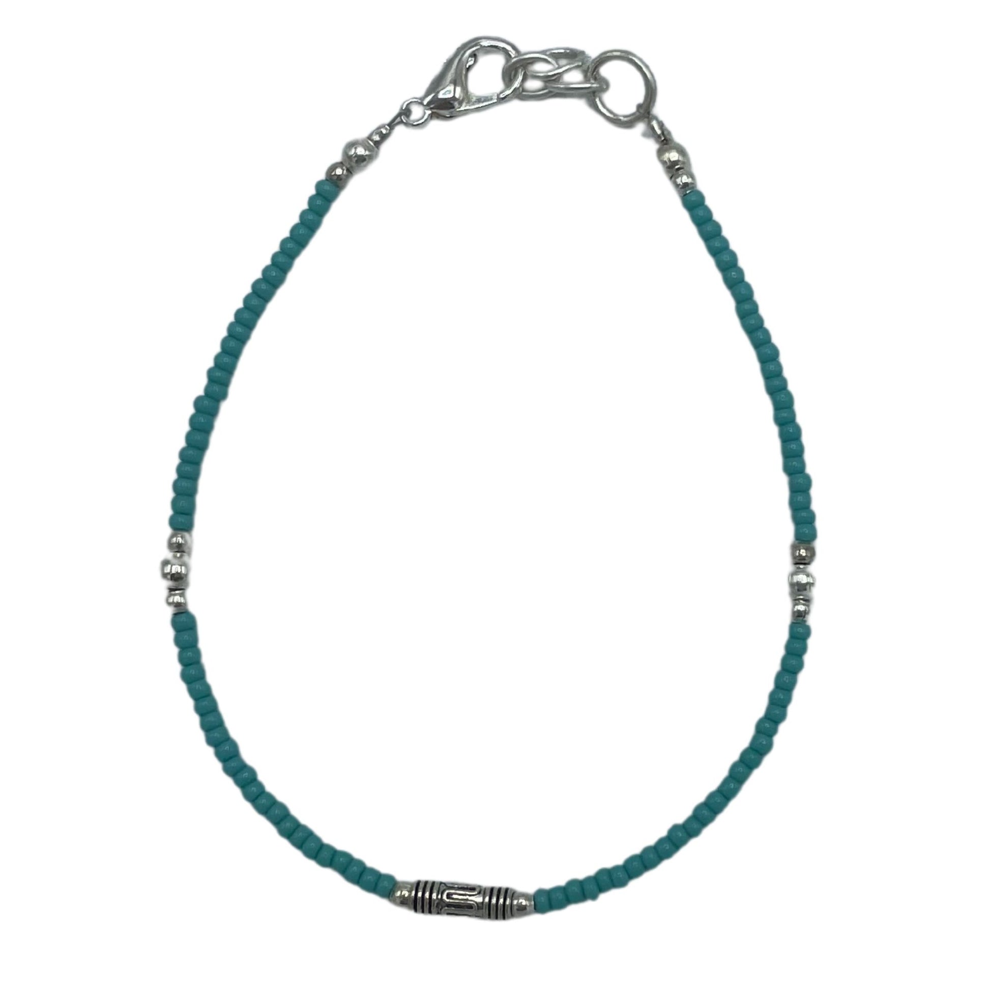 Pulsera de cuentas turquesa con detalles plateados, estilo bohemio y cierre de acero inoxidable.