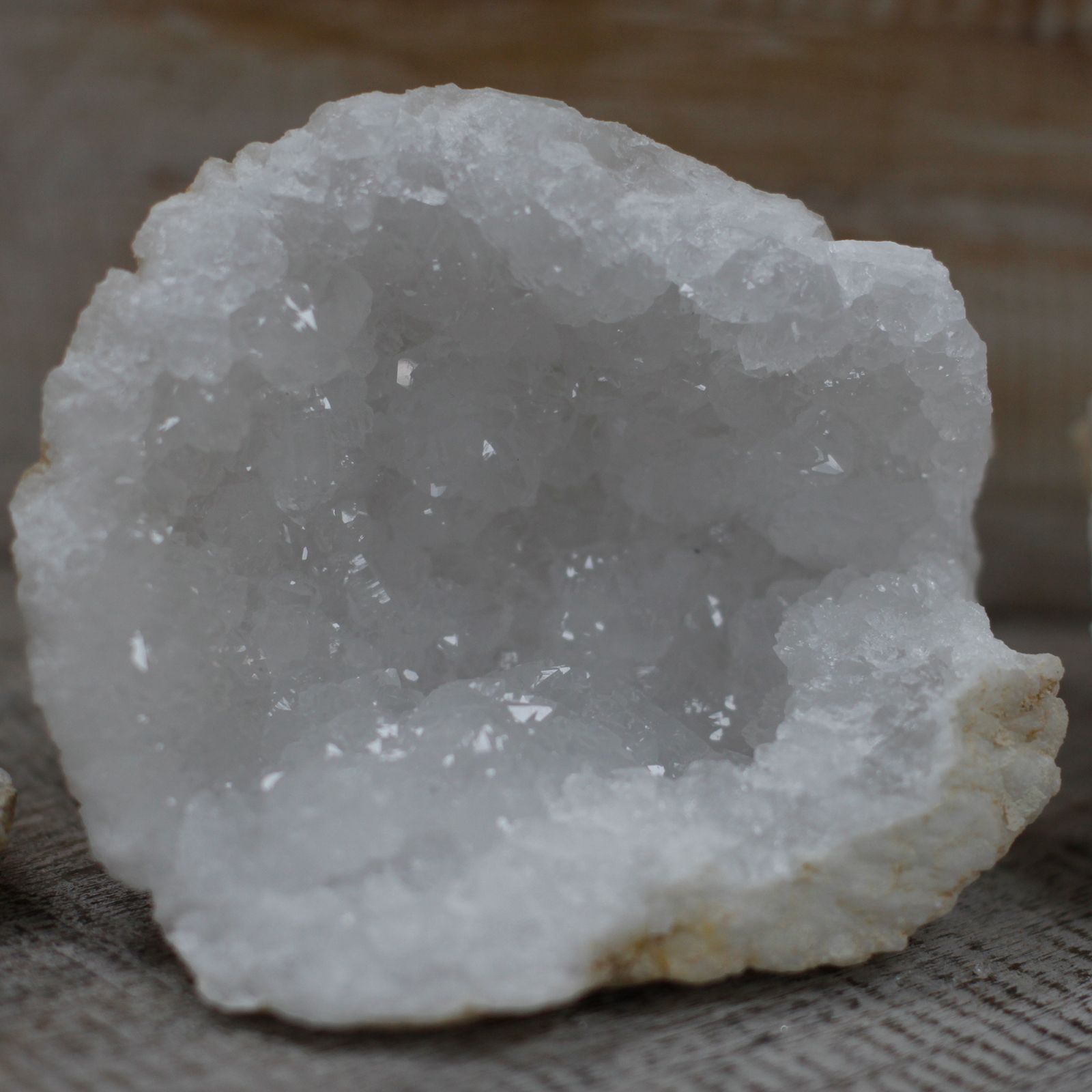 Geoda de cristal blanco, con interior brillante y textura mineral, ideal para decoración y coleccionismo.