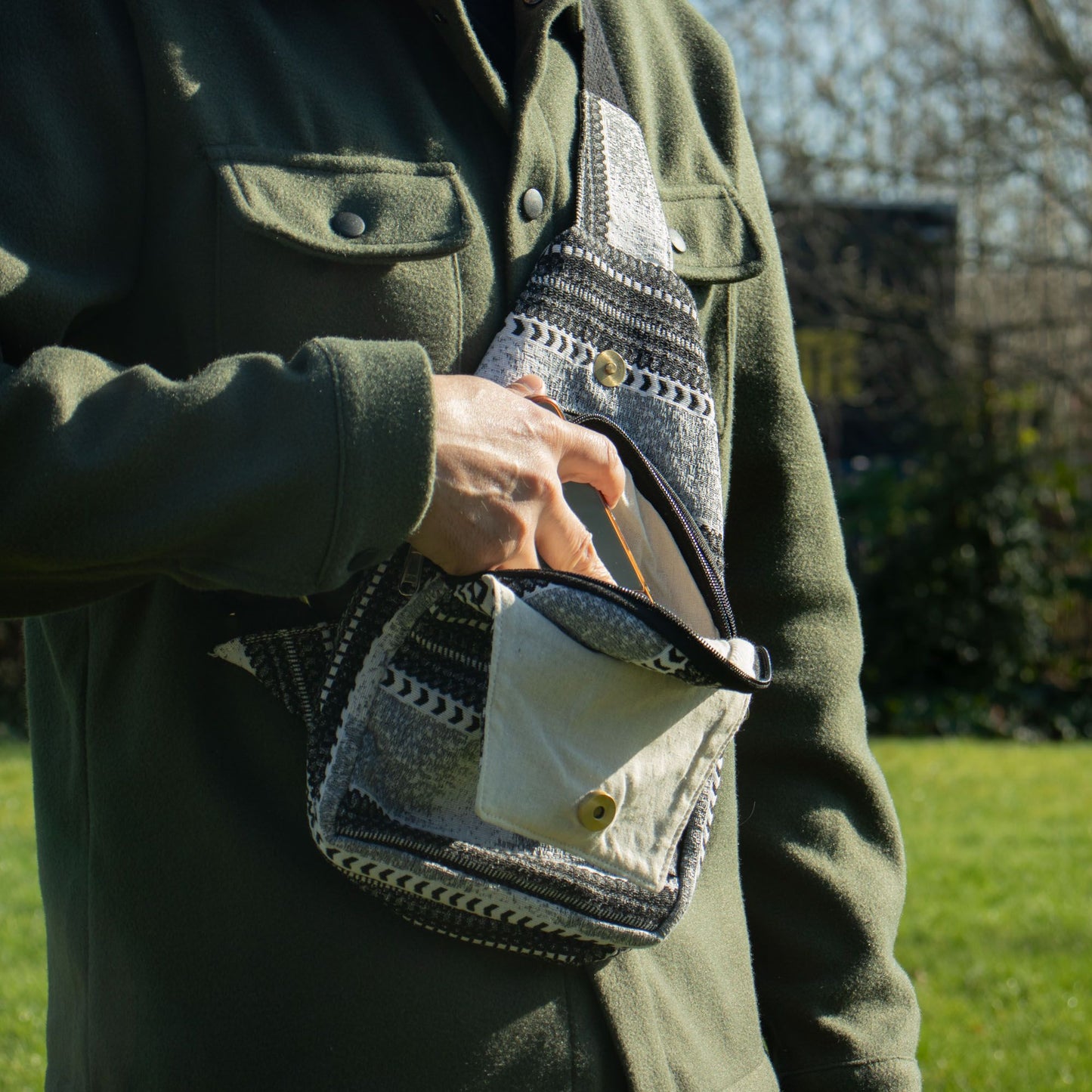 Bolso sling de algodón gris y blanco con diseño étnico, ideal para uso diario y actividades al aire libre.