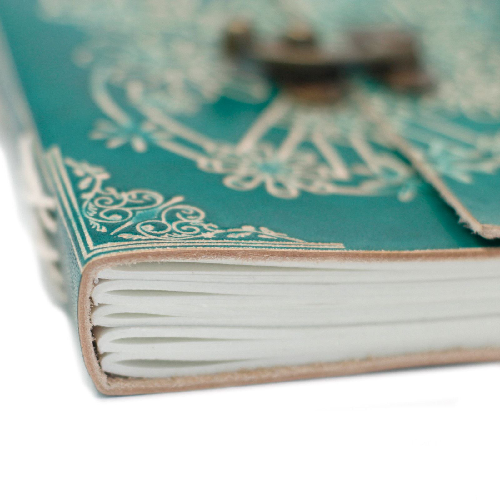 Cuaderno verde turquesa con detalles dorados y cierre metálico, páginas en blanco, estilo vintage.