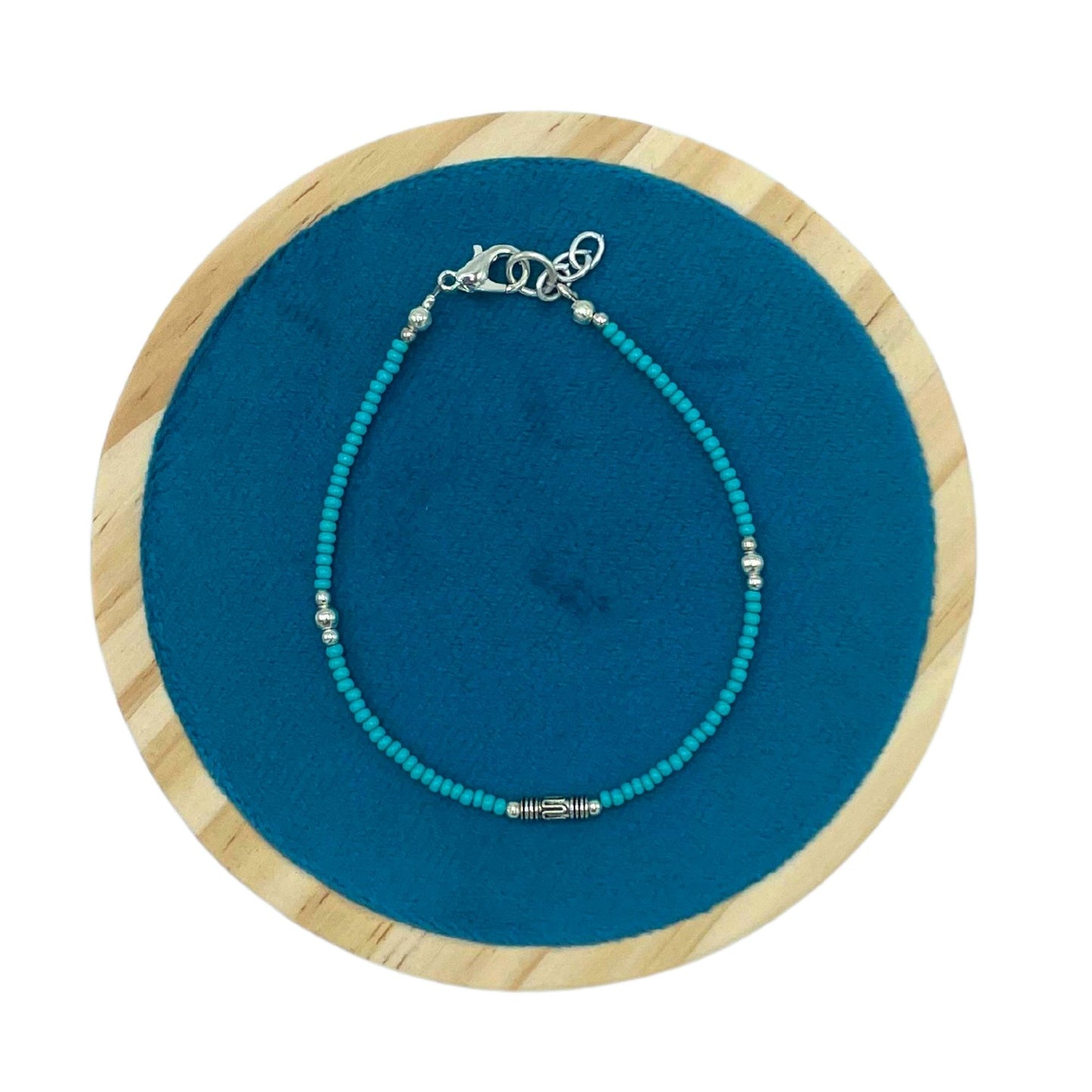 Collar de cuentas turquesas con detalles plateados, estilo bohemio, sobre fondo azul.