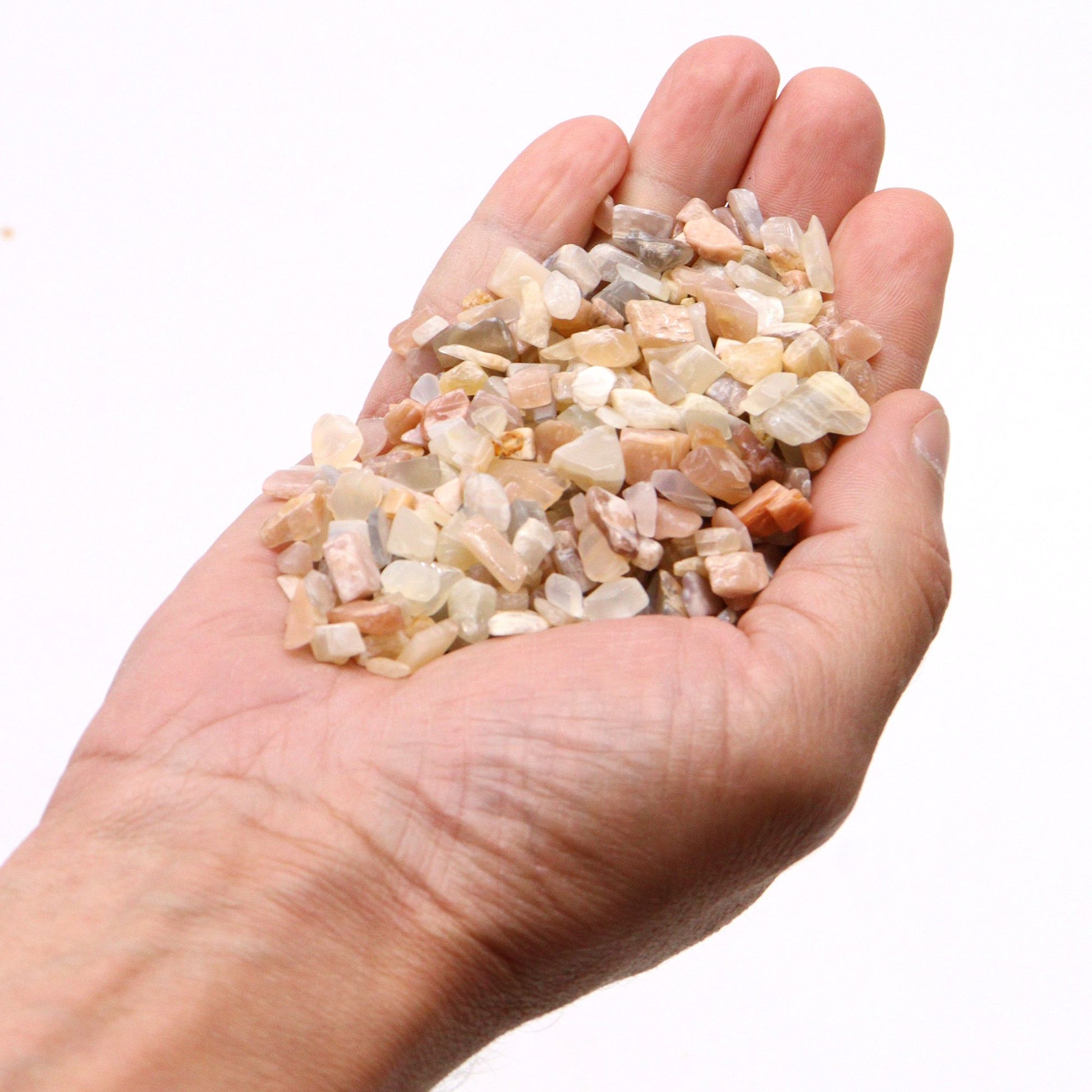 Piedras semipreciosas variadas en tonos beige, rosa y gris, perfectas para manualidades y decoración.