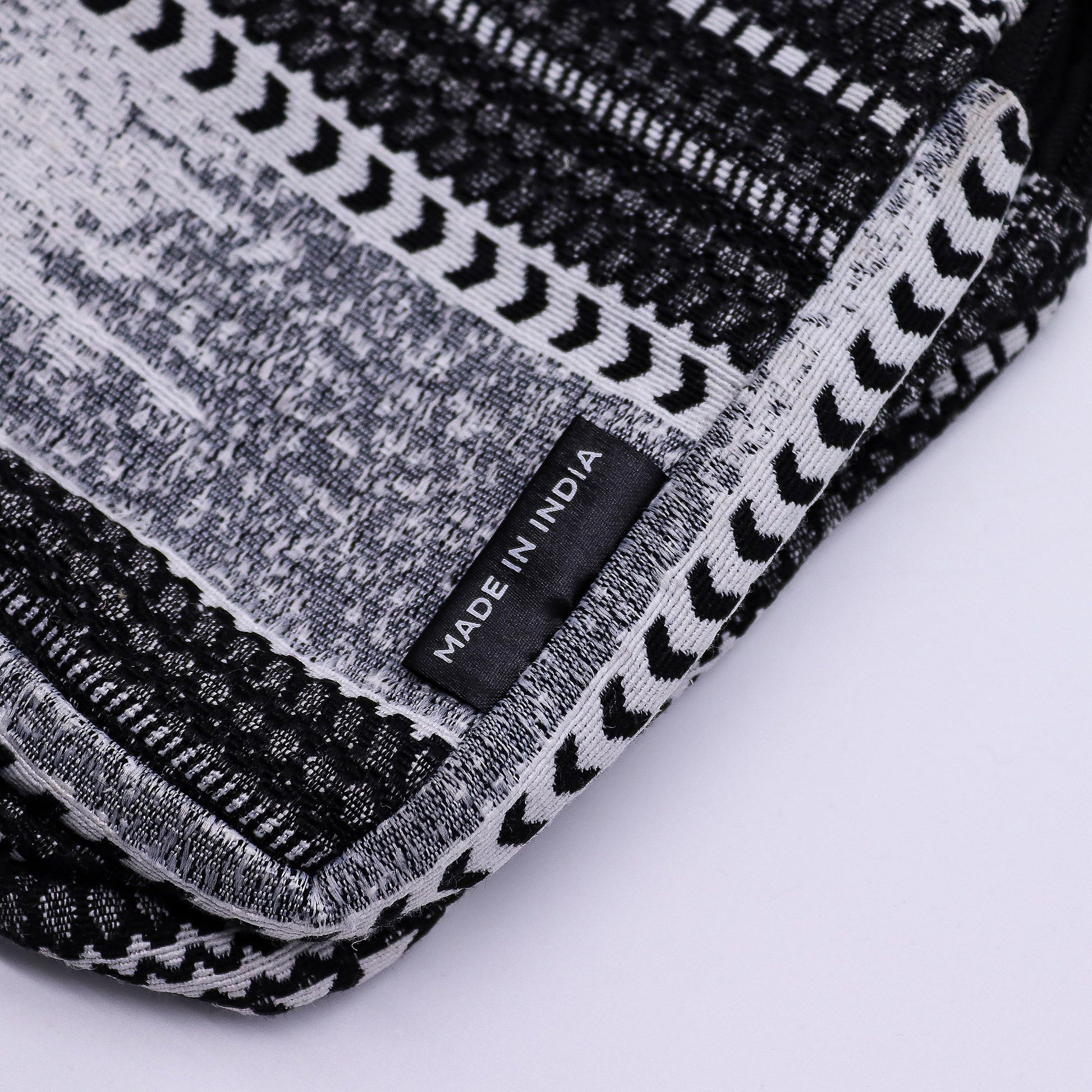 Funda de tela negra y blanca, patrón geométrico, hecha en India, ideal para proteger dispositivos electrónicos.