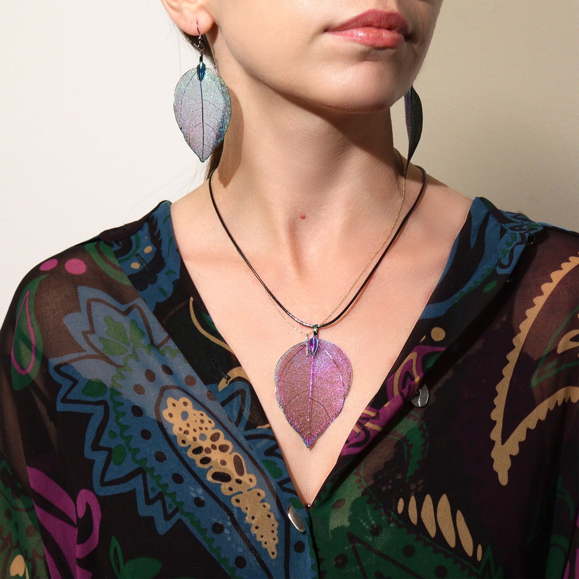 Collar y aretes de hojas en tonos púrpura y azul, hechos de metal, estilo bohemio y colorido.