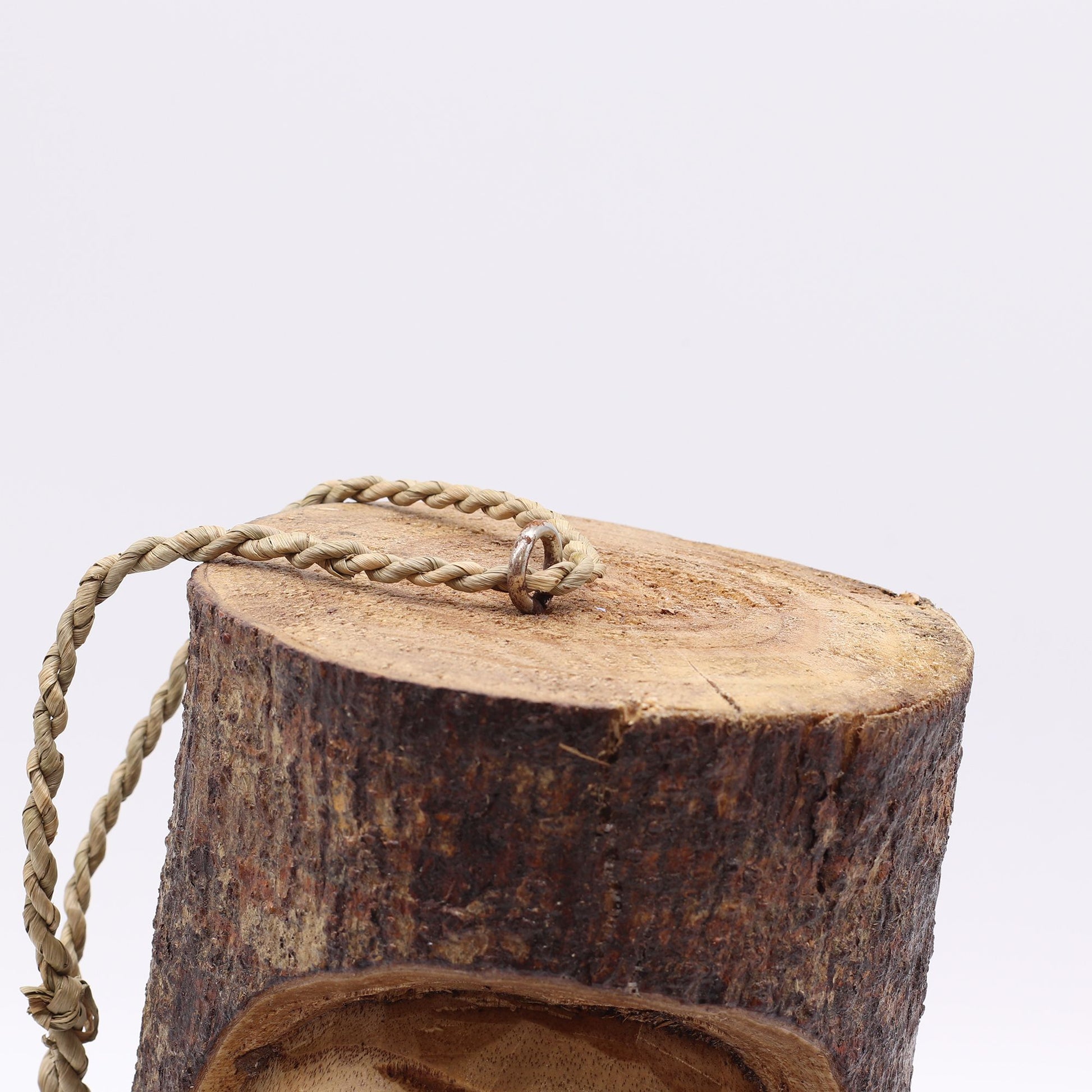 Bloque de madera natural con cuerda trenzada beige, ideal para decoraciones rústicas y artesanales.