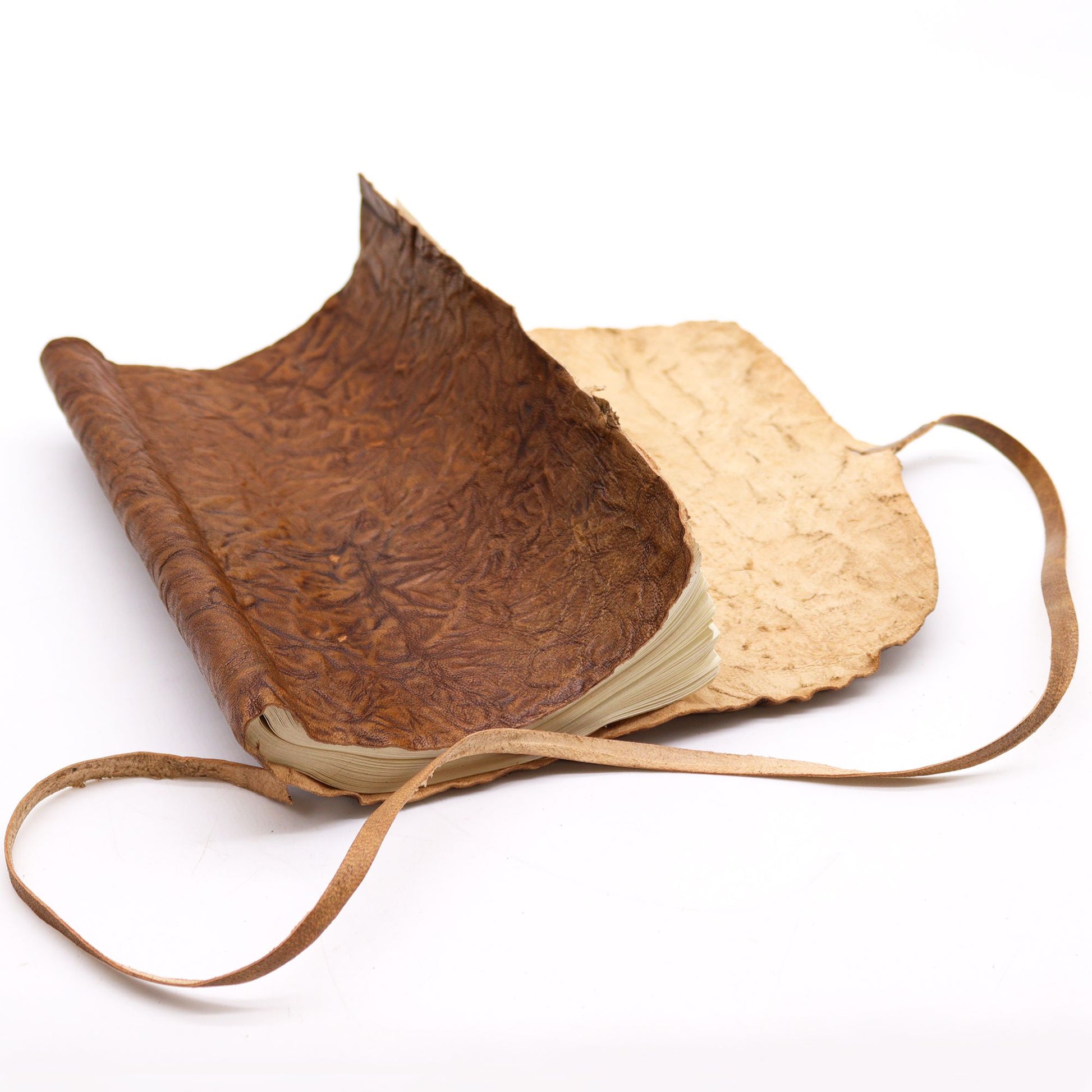 Cuaderno de cuero marrón con papel crudo, diseño rústico y tapa de textura arrugada. Ideal para notas y bocetos.