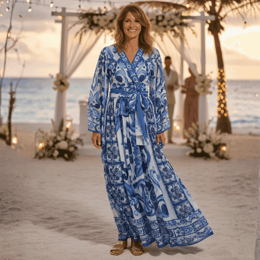 Blue and white floral printed maxi dress with long sleeves and a tie waist, perfect for beach weddings.