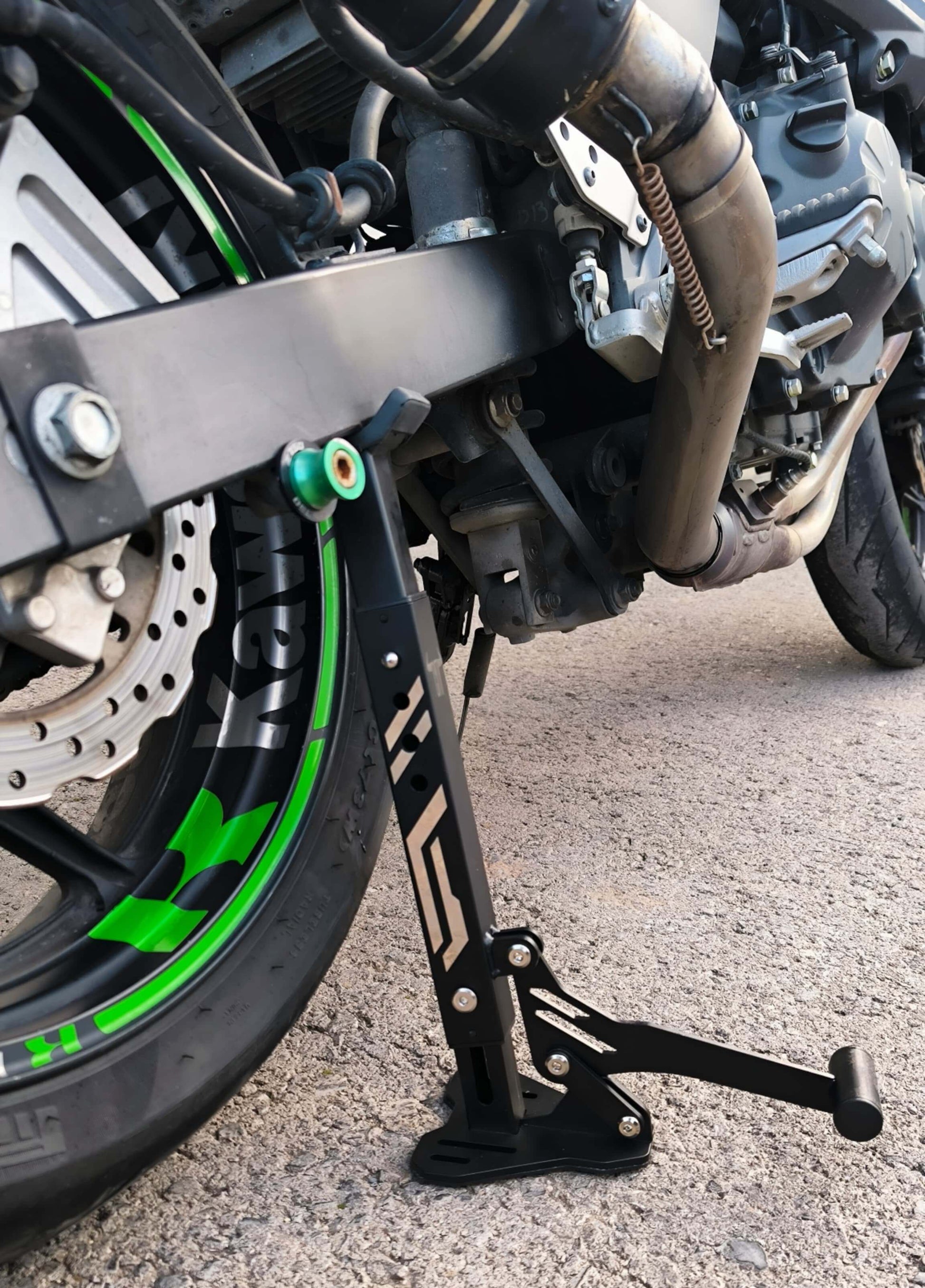 Caballete compacto PRO instalado en eje trasero de moto Kawasaki - uso real